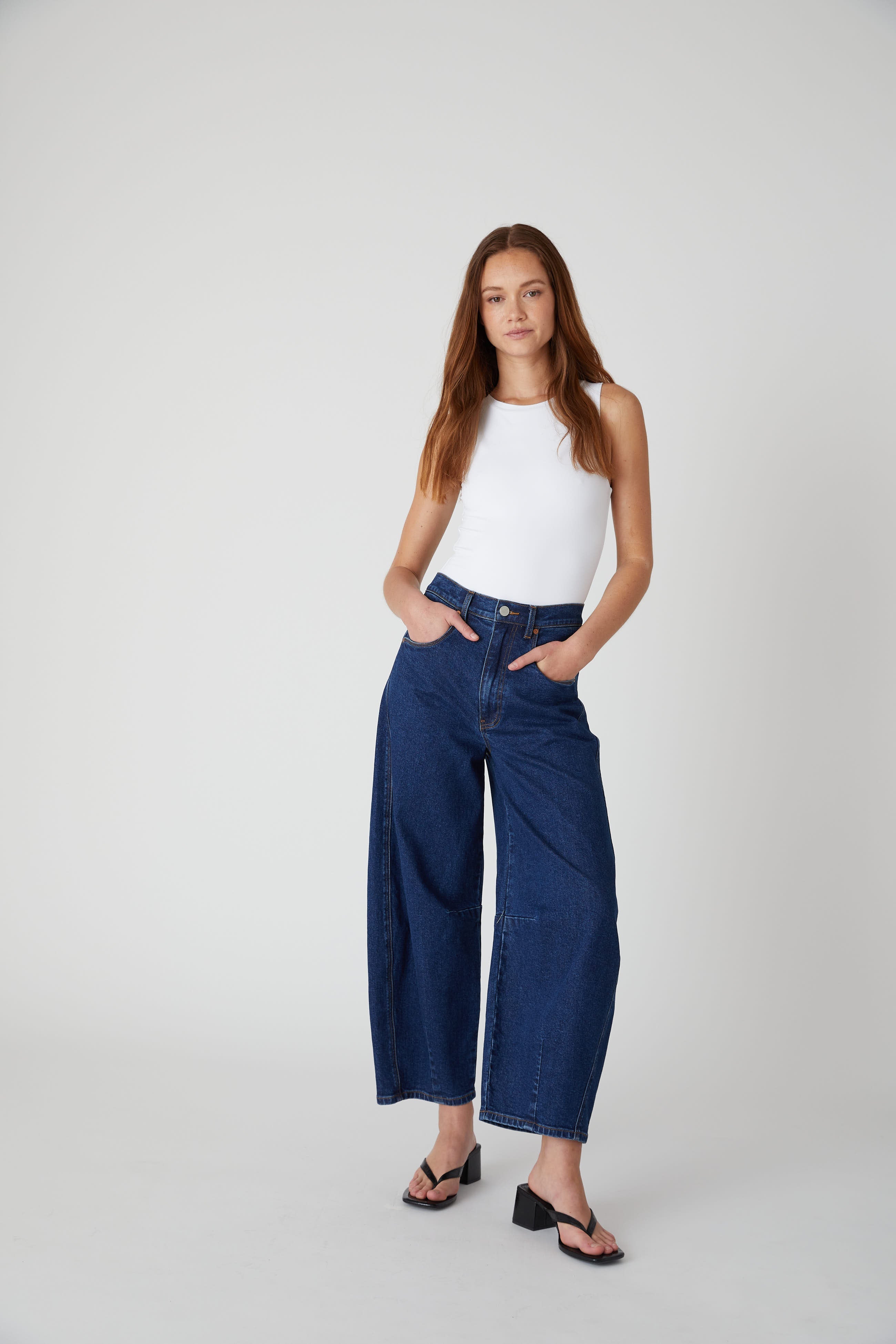 Model wearing the BLANKNYC Deep Down Barrel Jean in Dark Indigo, front view.