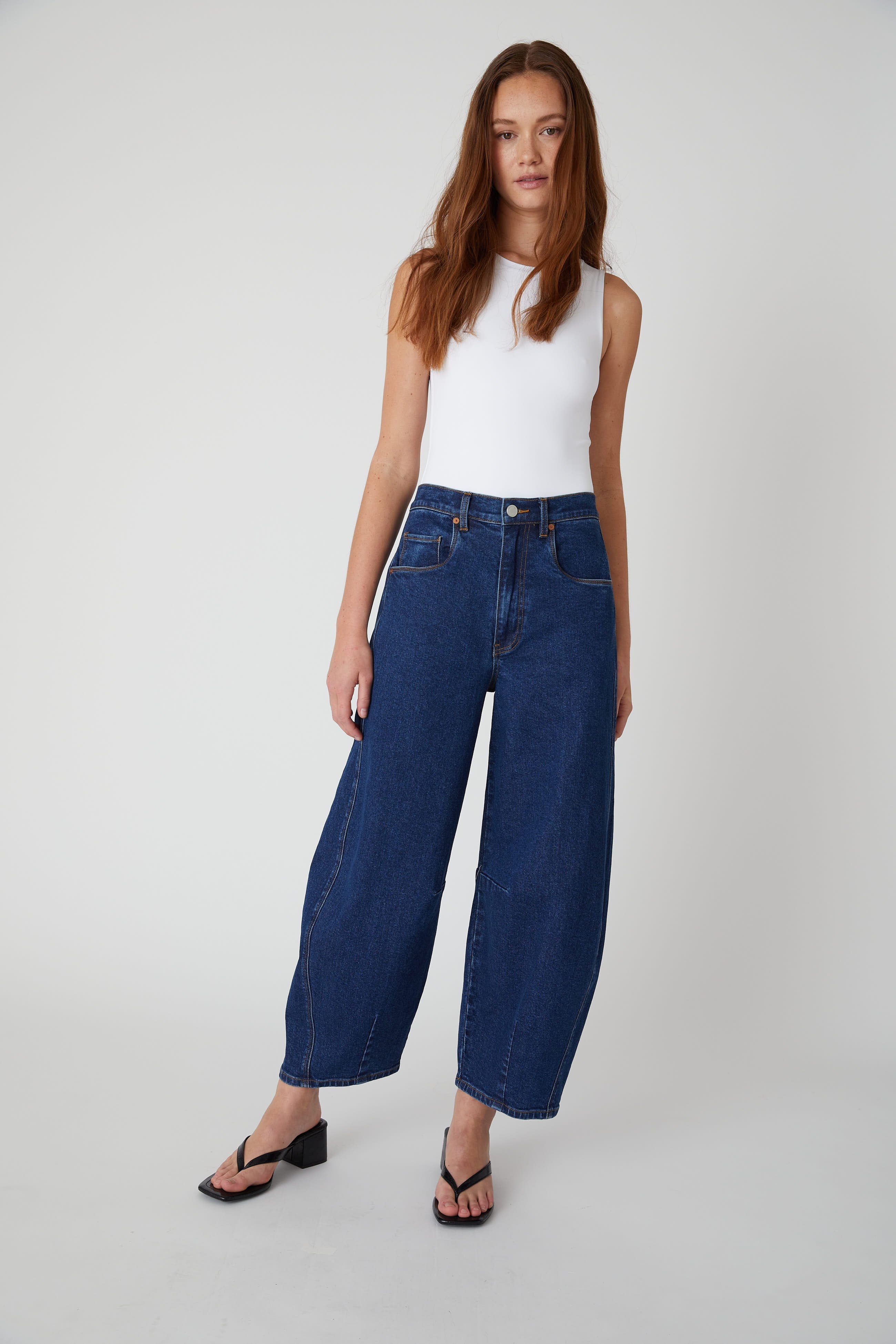 Model wearing the BLANKNYC Deep Down Barrel Jean in Dark Indigo, front view.