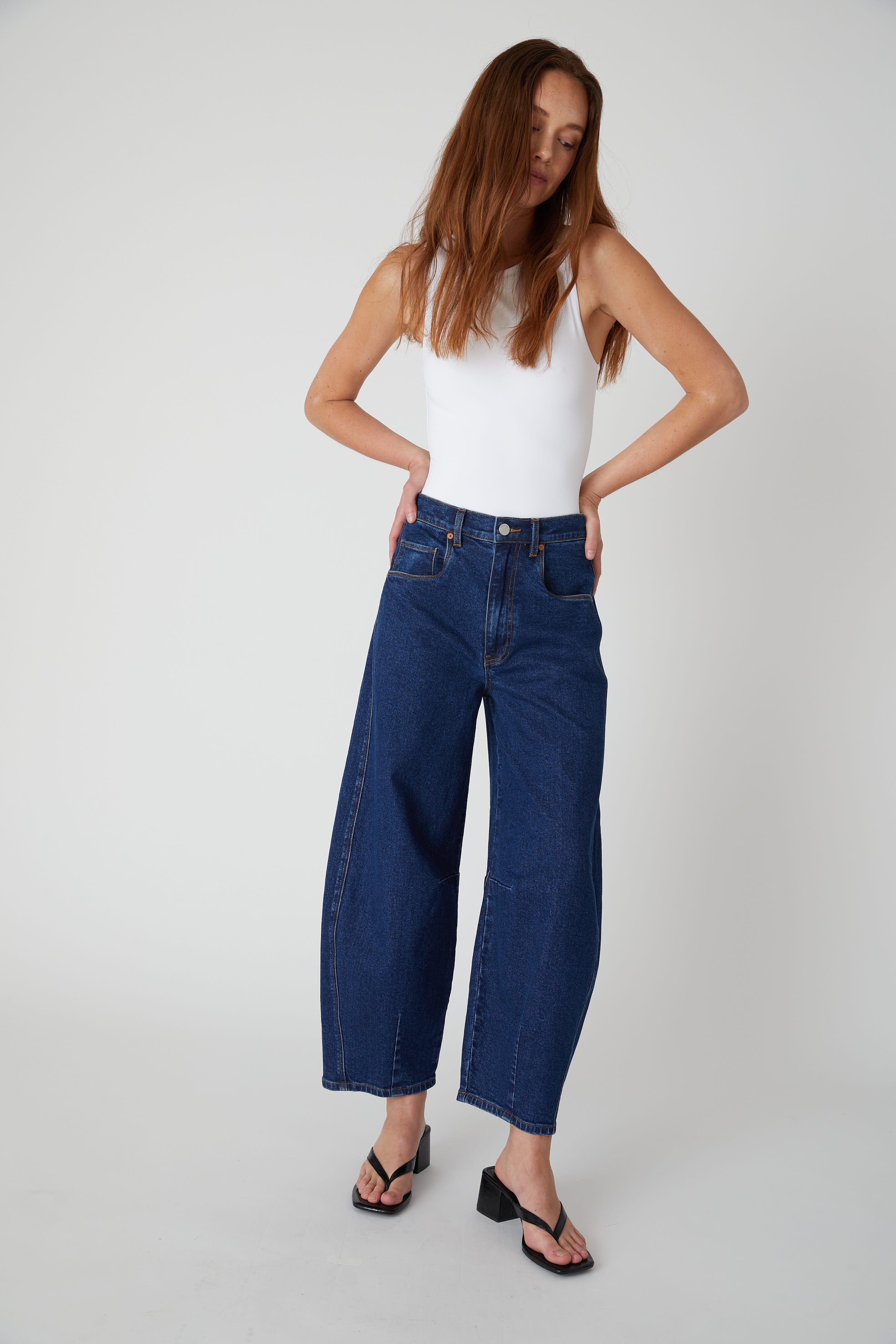 Model wearing the BLANKNYC Deep Down Barrel Jean in Dark Indigo, front view.