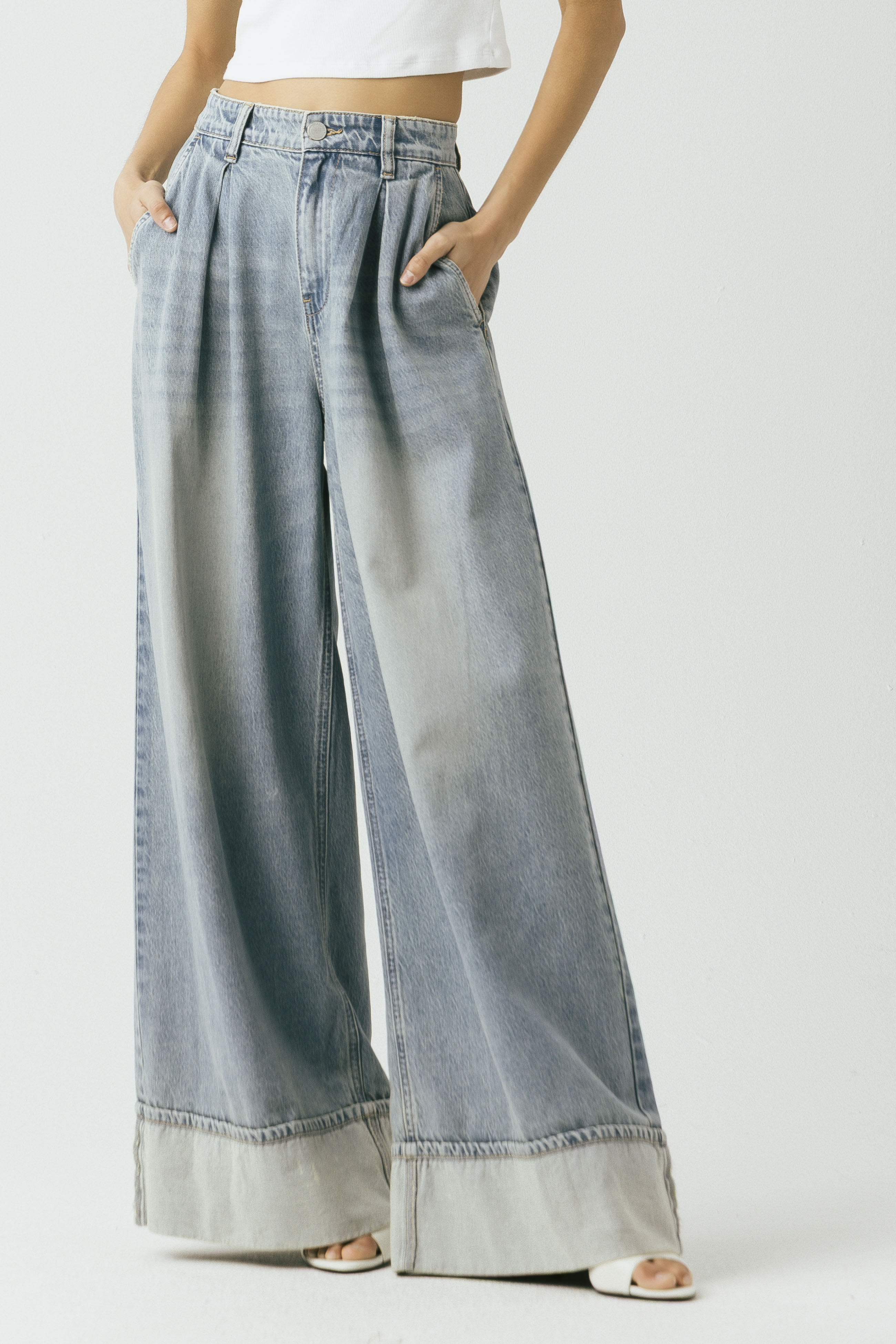 Model wearing the Blank NYC Easy Day Pleated Wide-Leg Denim Trouser in Light Indigo Creative, front view.