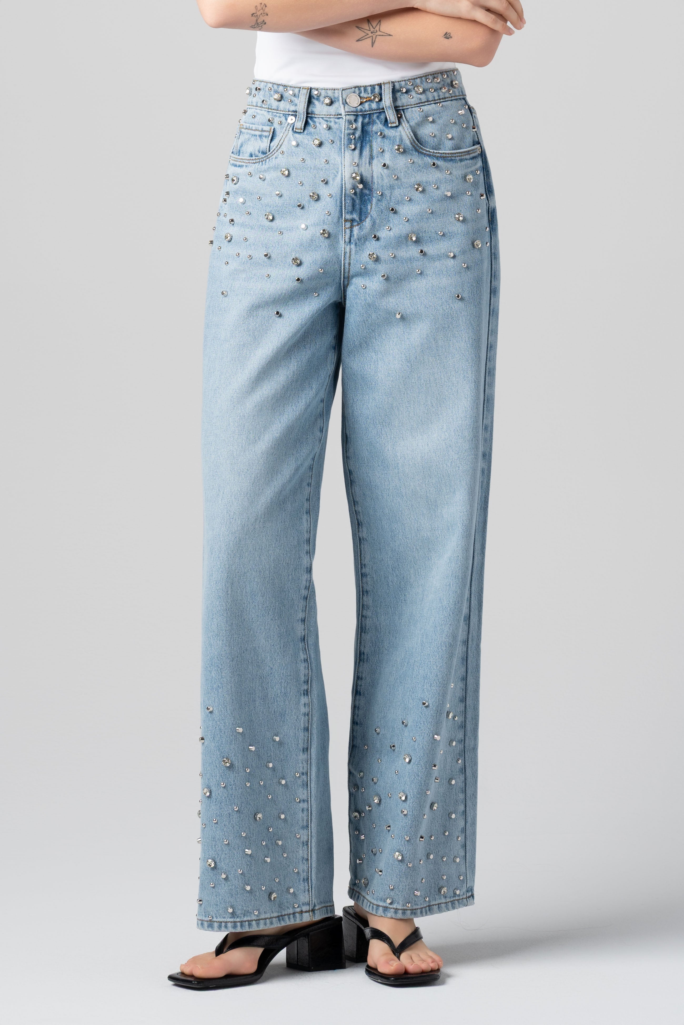 Model wearing the BLANKNYC Diamonds in the Sky Jean in Light Indigo with rhinestone embellishments, front view.