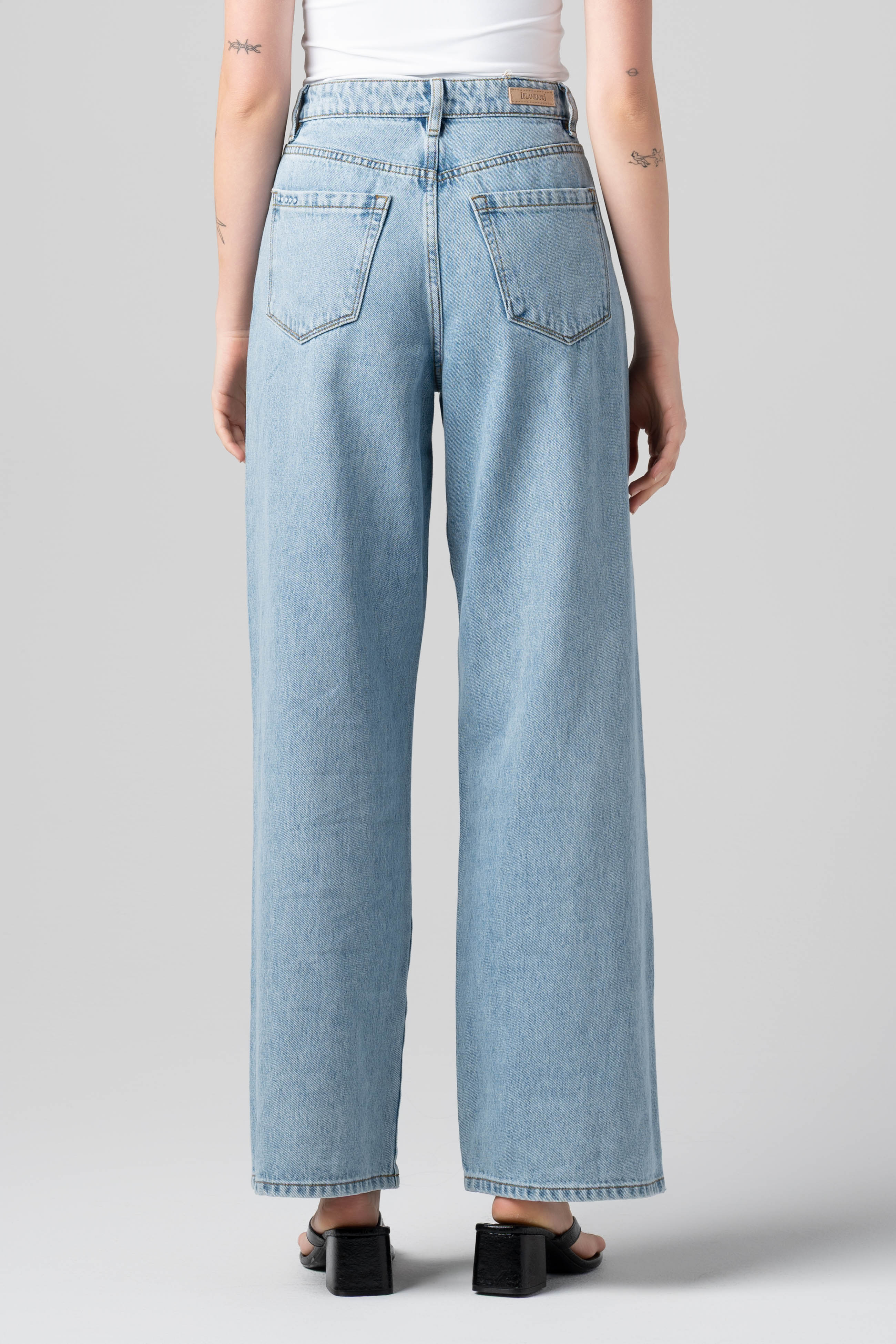 Back view of a model wearing the BLANKNYC Diamonds in the Sky Jean in Light Indigo.