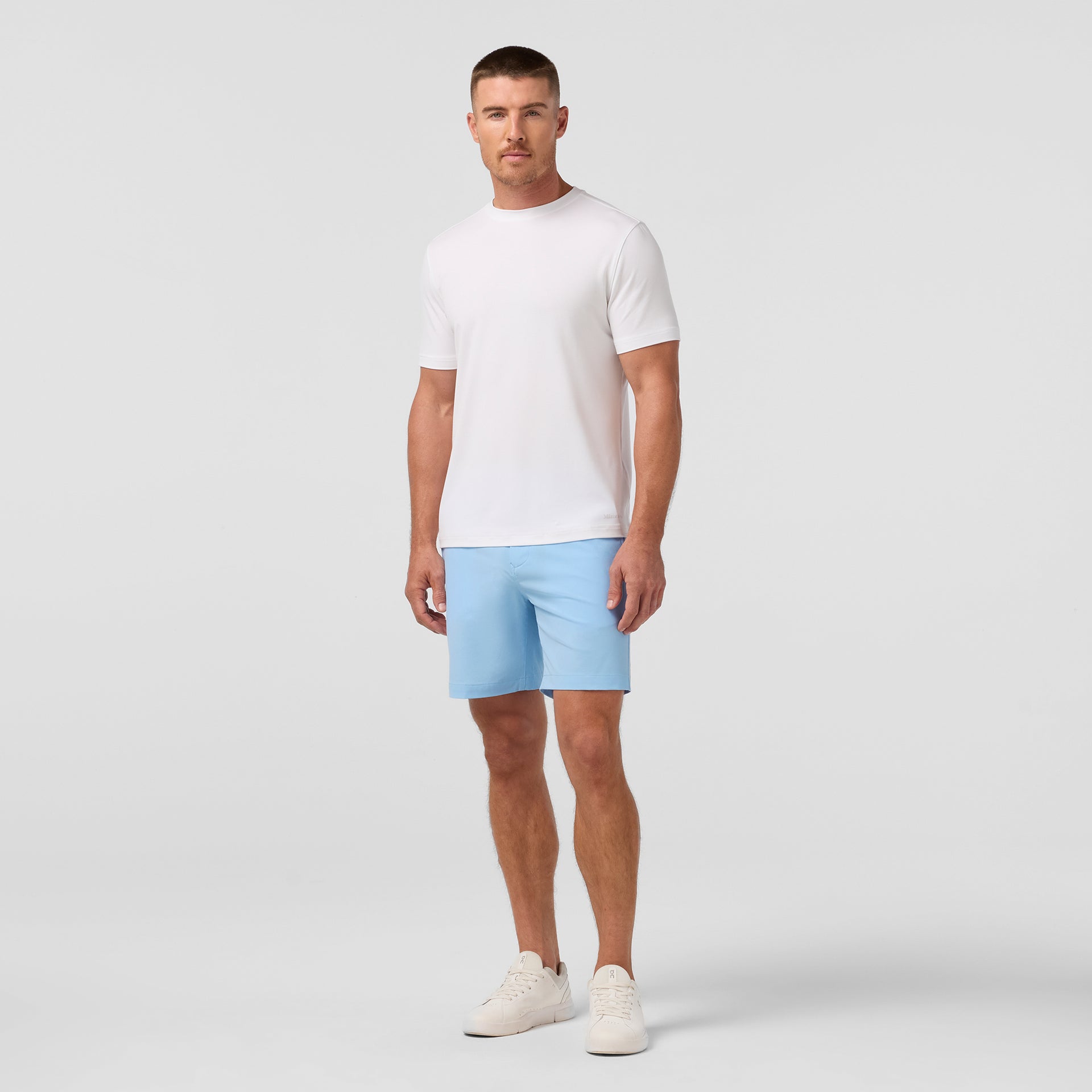 Model wearing Mizzen+Main Helmsman Short in Cloud Blue (light blue), with a lightweight white top.