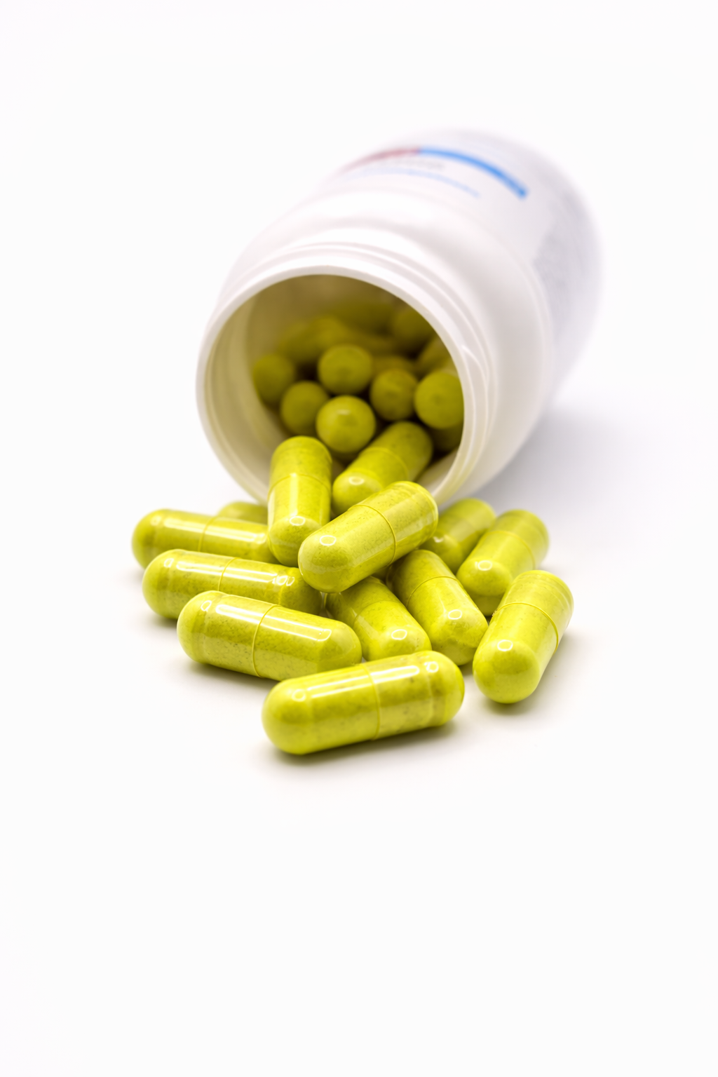 Bottle of Cooper Complete Berberine Complex with bright yellow-green capsules spilling out of the white plastic bottle onto a clean white background.