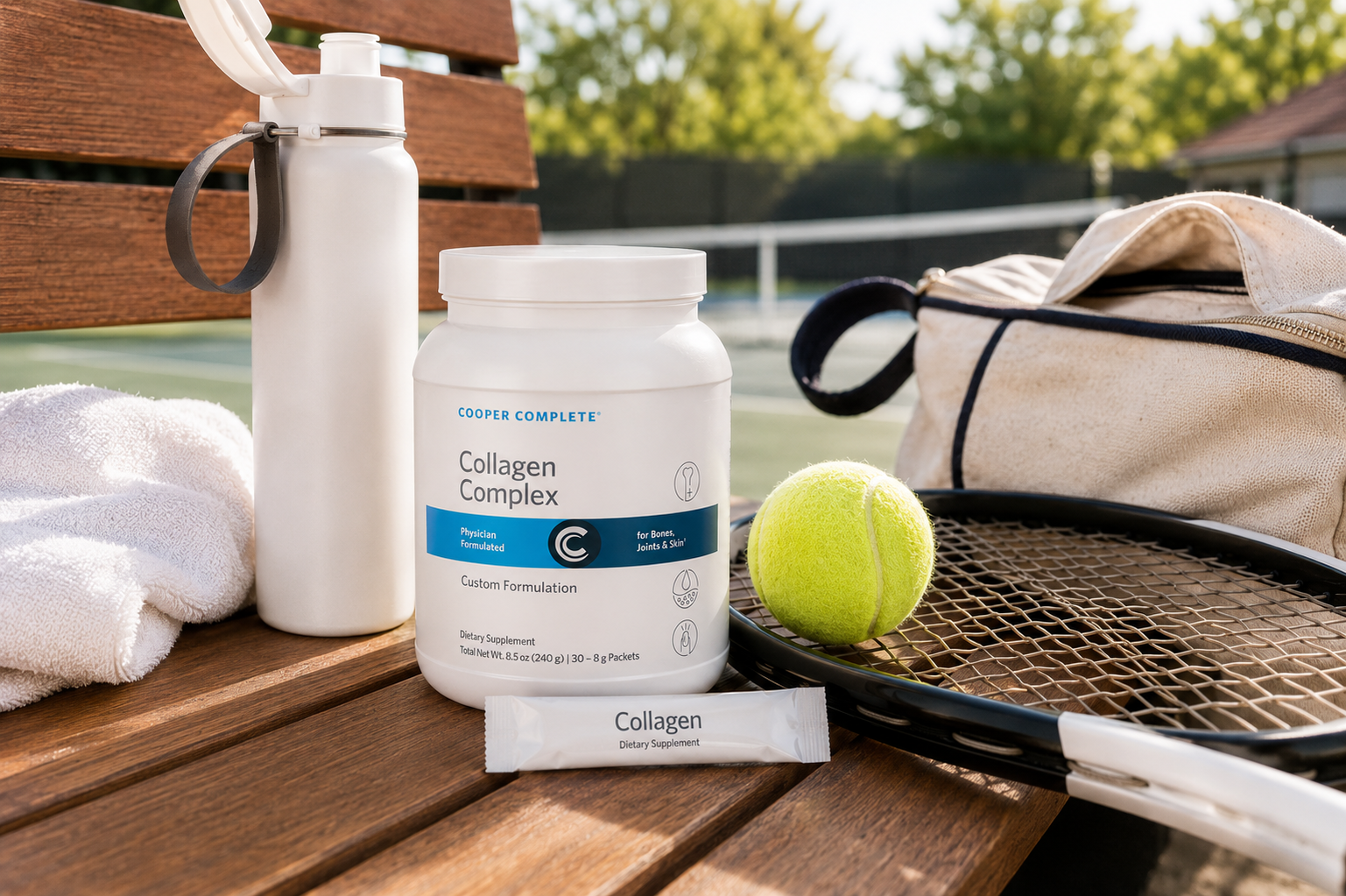 Cooper Complete Collagen Complex supplement canister and single-serving sachet displayed on a wooden bench with a water bottle, towel, tennis ball, and racket on a tennis court background.
