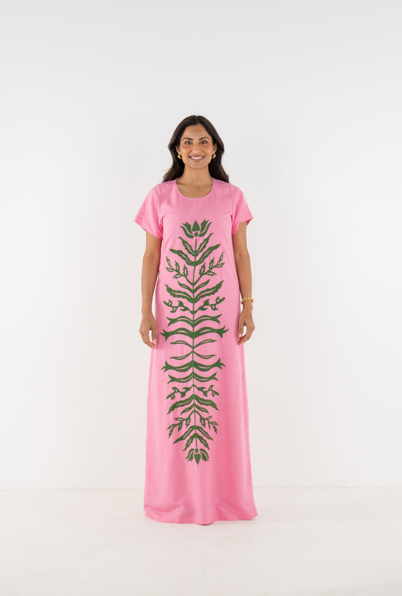 Model wearing the Emily McCarthy Cornelia Dress in Rosé, front view, featuring dark green floral appliqué.