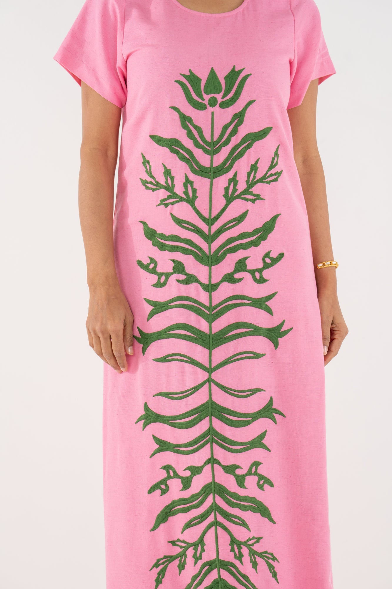 Close-up of the Emily McCarthy Cornelia Dress in Rosé, highlighting the dark green floral appliqué.