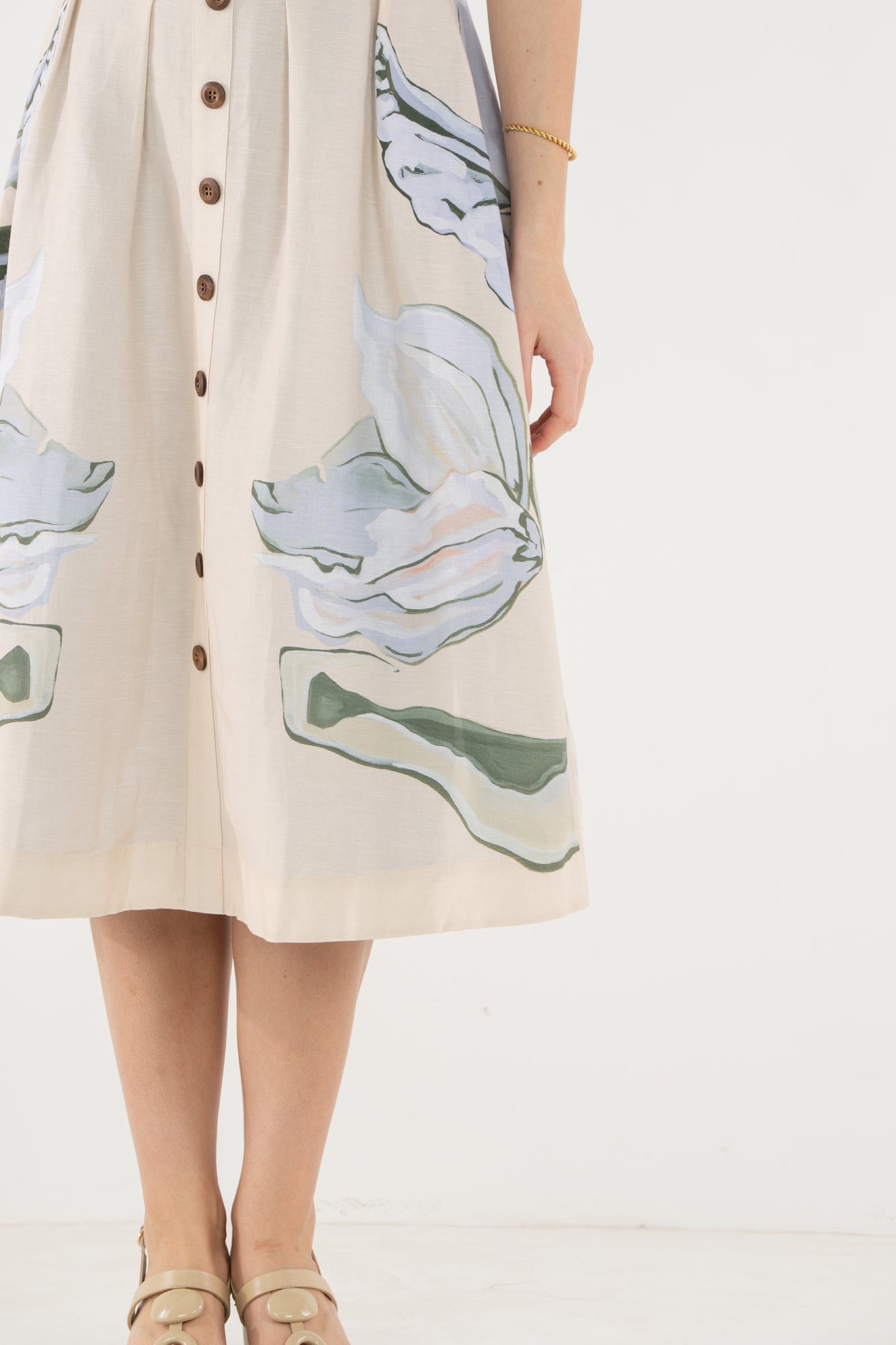 Close-up of the Emily McCarthy Constance Midi Dress, highlighting the Lavender Fields botanical print in green and blue on a cream background.