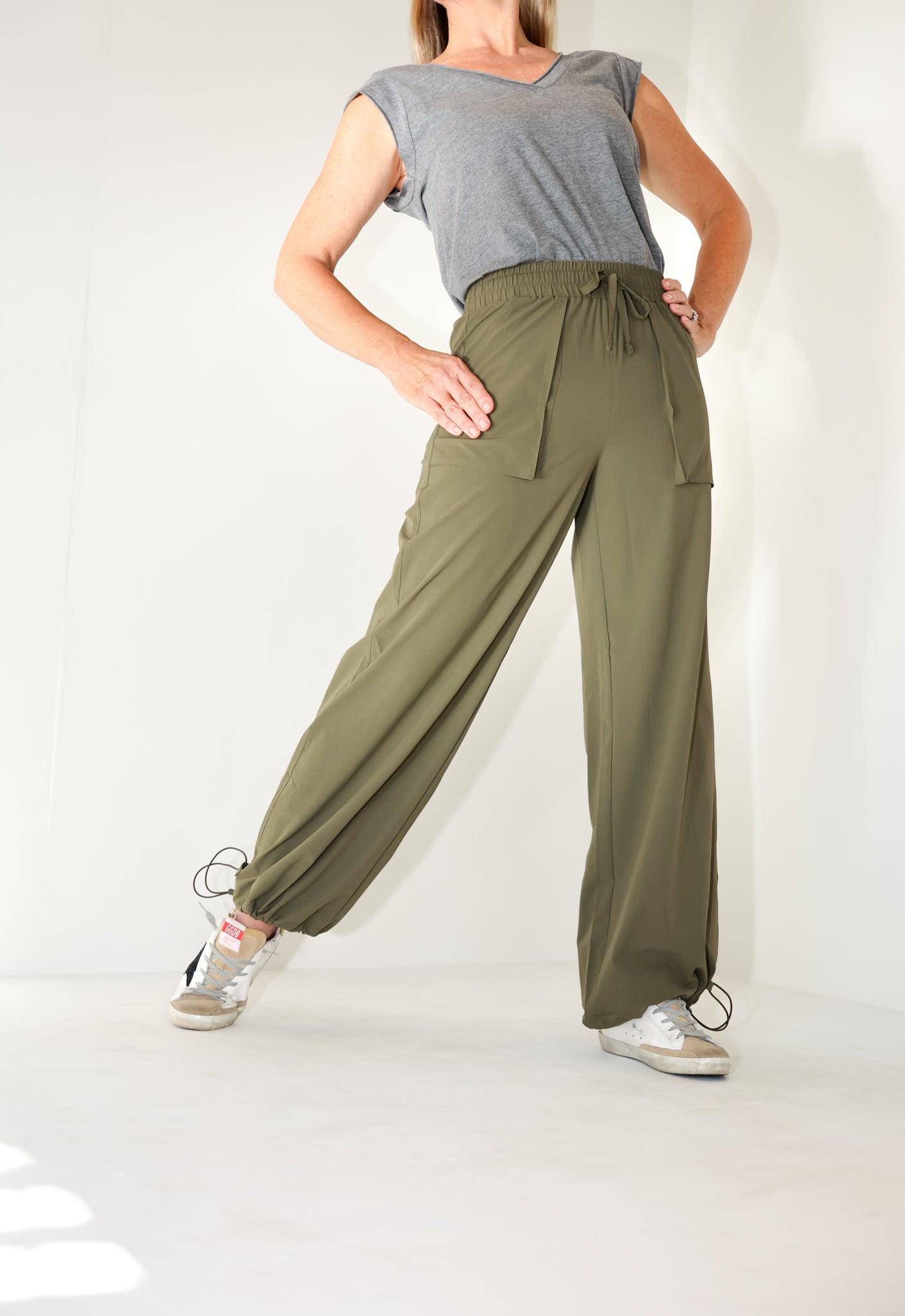 Model wearing the Be Fit Convertible Cargo Pant in green, front view.