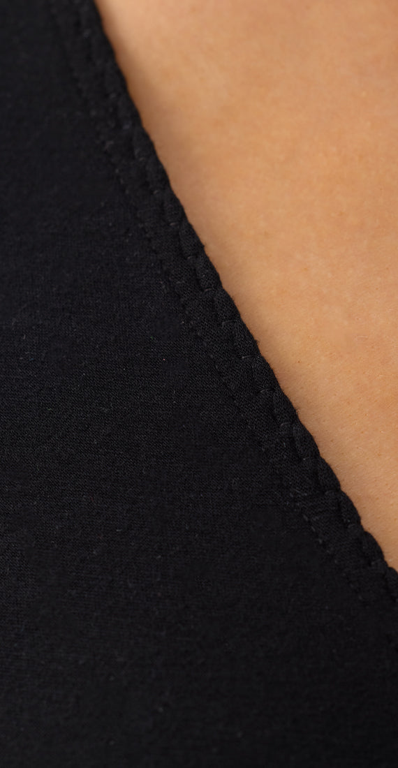 Close-up of the Be Fit x Glee black onyx fabric and stitched trim along the V-neckline of the Ballerina Wrap.