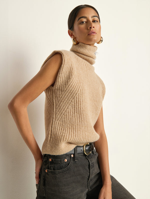 Side view of a model wearing the Nation Los Angeles Isha Turtleneck Tank in Shiny Moonbeam.