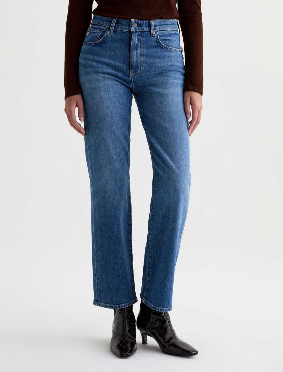 Front view of the AG Jeans Brinley Mid-Rise Jean in Chord on a model, showing the mid-rise waist, whiskering and straight-leg fit.