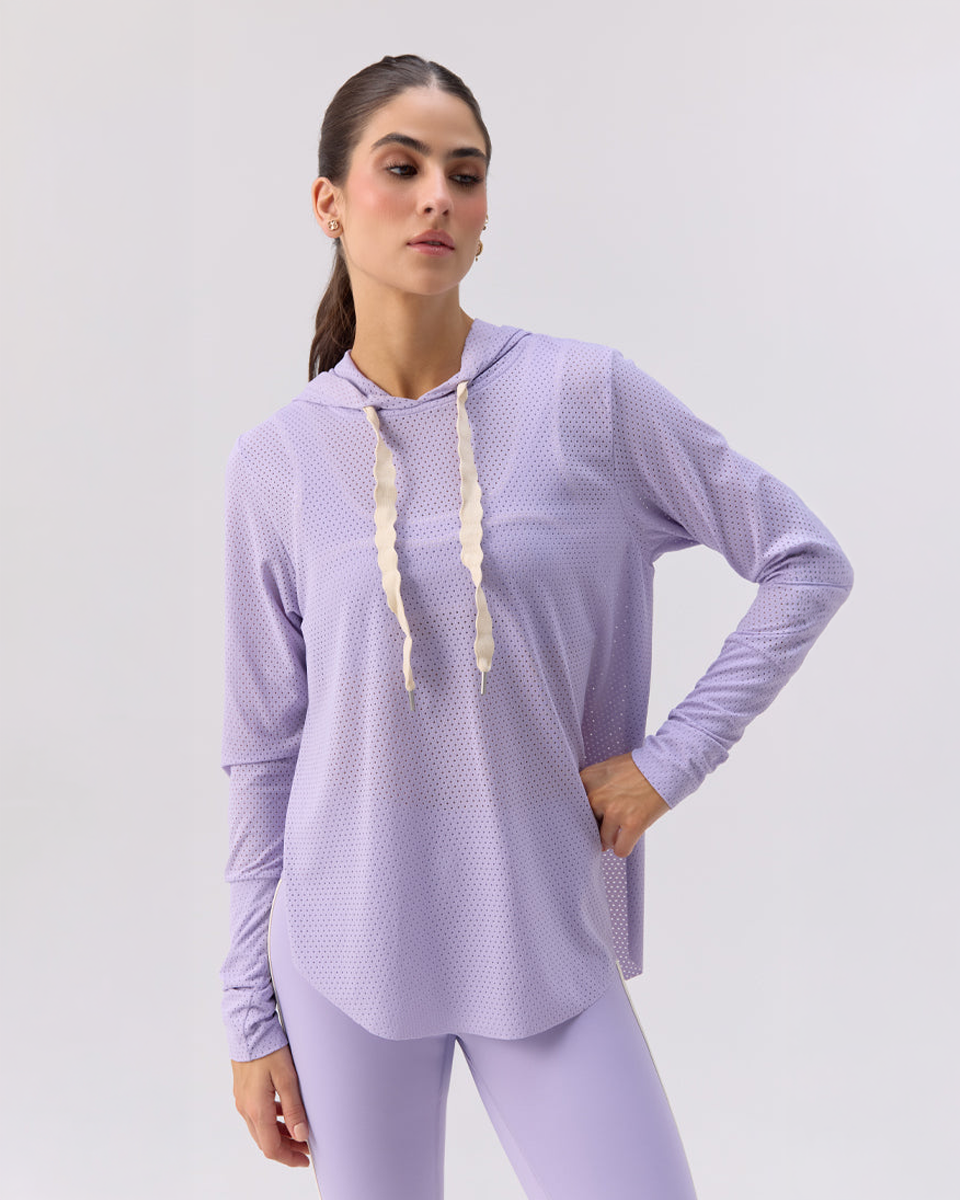Woman wearing a Glee Be Fit light purple long-sleeve athletic top with a hood on a white background