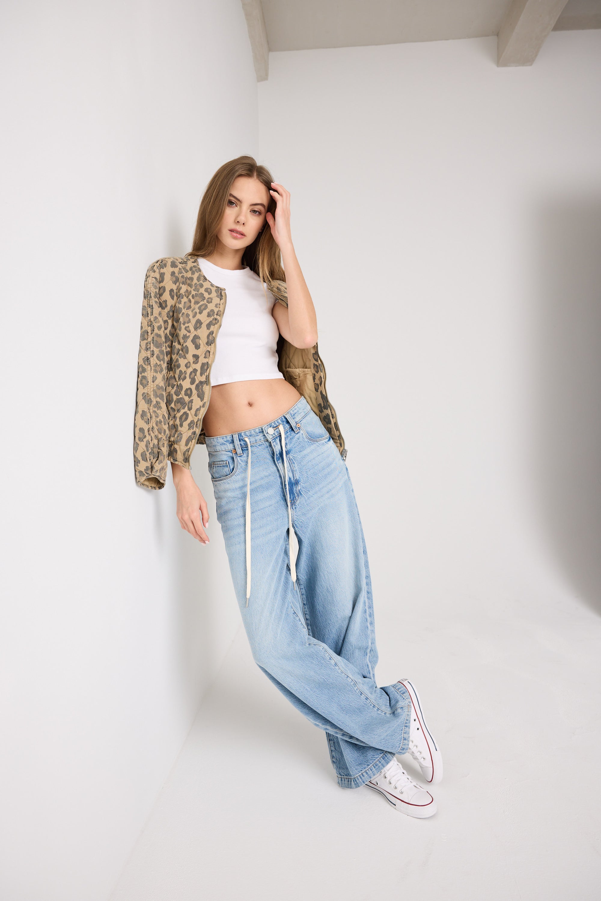Model wearing the BLANKNYC Feeling Good Low-Rise Baggy Fit Denim Jean in Light Indigo, front view, highlighting the cool drawstring belt