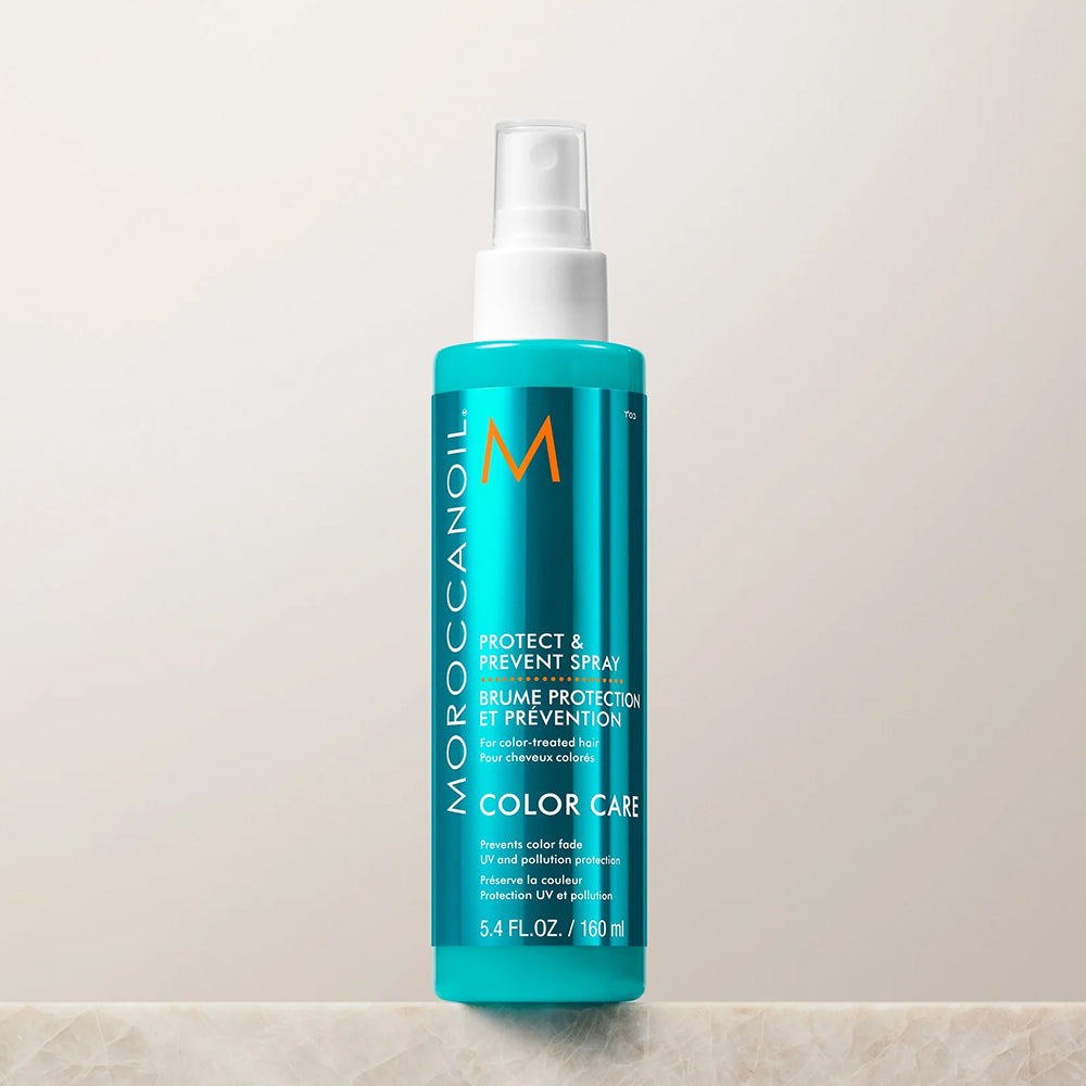 Moroccanoil Protect & Prevent Spray in a vibrant turquoise blue bottle with a white spray nozzle, set against a neutral light beige background.