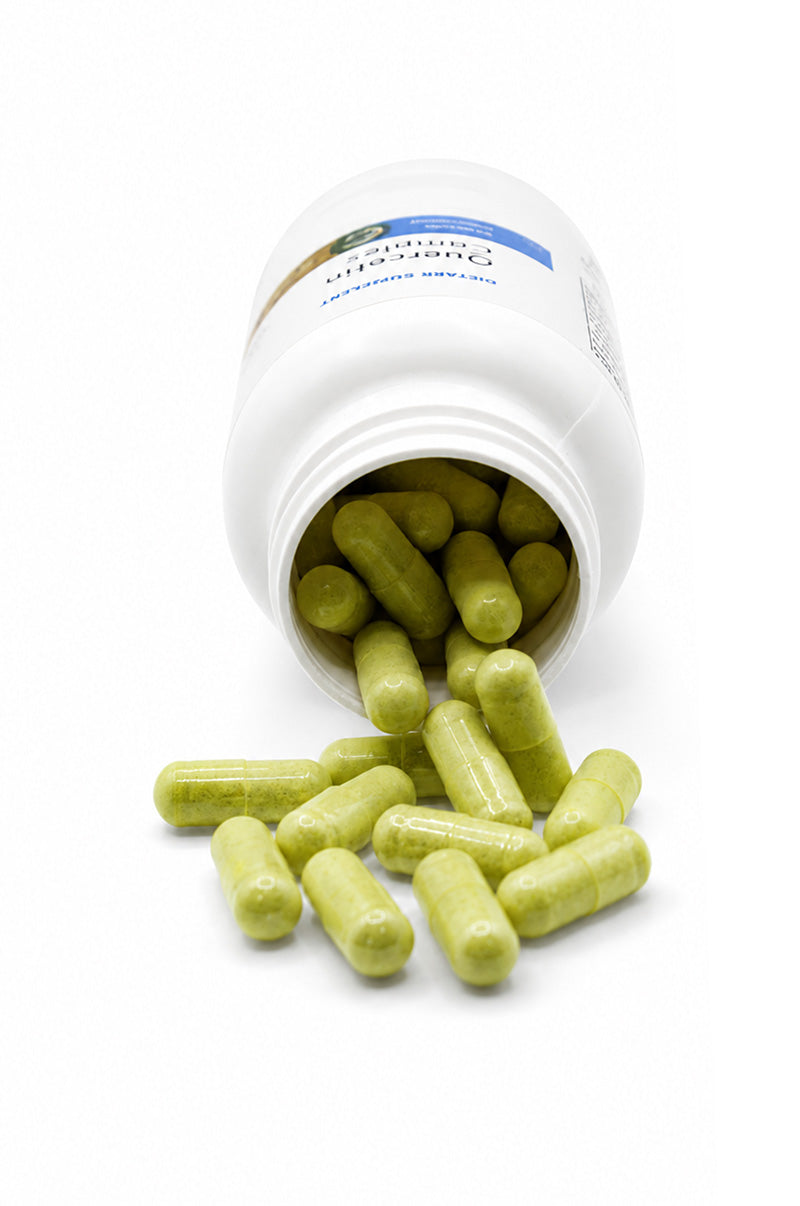 Open white Cooper Complete Quercetin Complex Supplement pill bottle with capsules spilling out on a white background