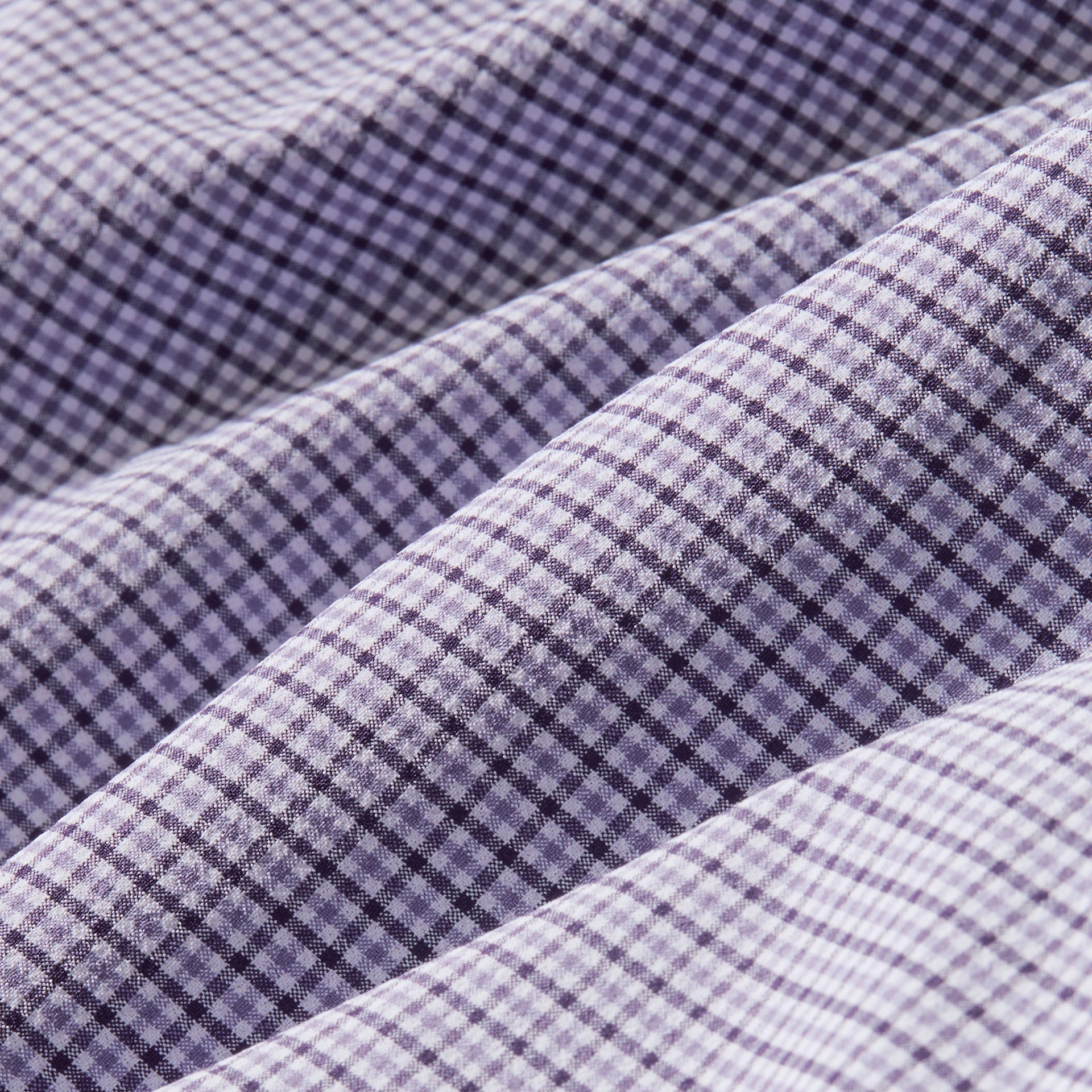 Fabric swatch of the Mizzen+Main Leeward Long Sleeve Dress Shirt in Purple Dusk Sam Plaid (soft lavender and navy plaid), showing the lightweight four-way stretch performance fabric and plaid pattern.