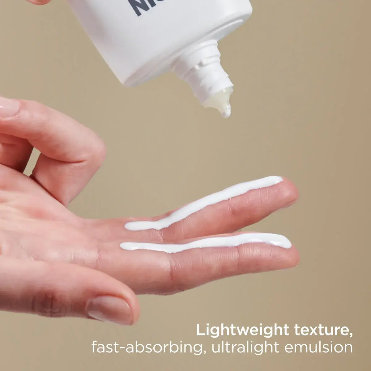 Squeezing ISDIN Eryfotona Actinica SPF 50+ onto fingers in front of a beige background, showing its fast-absorbing lightweight texture with ultralight emulsion.