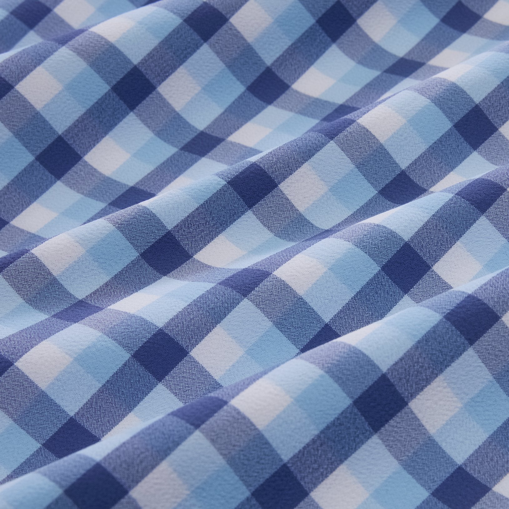 Close-up of light blue, dark blue, and white checkered fabric used in the Mizzen + Main Leeward LS Coastal Fjord Dylan Plaid Dress Shirt.