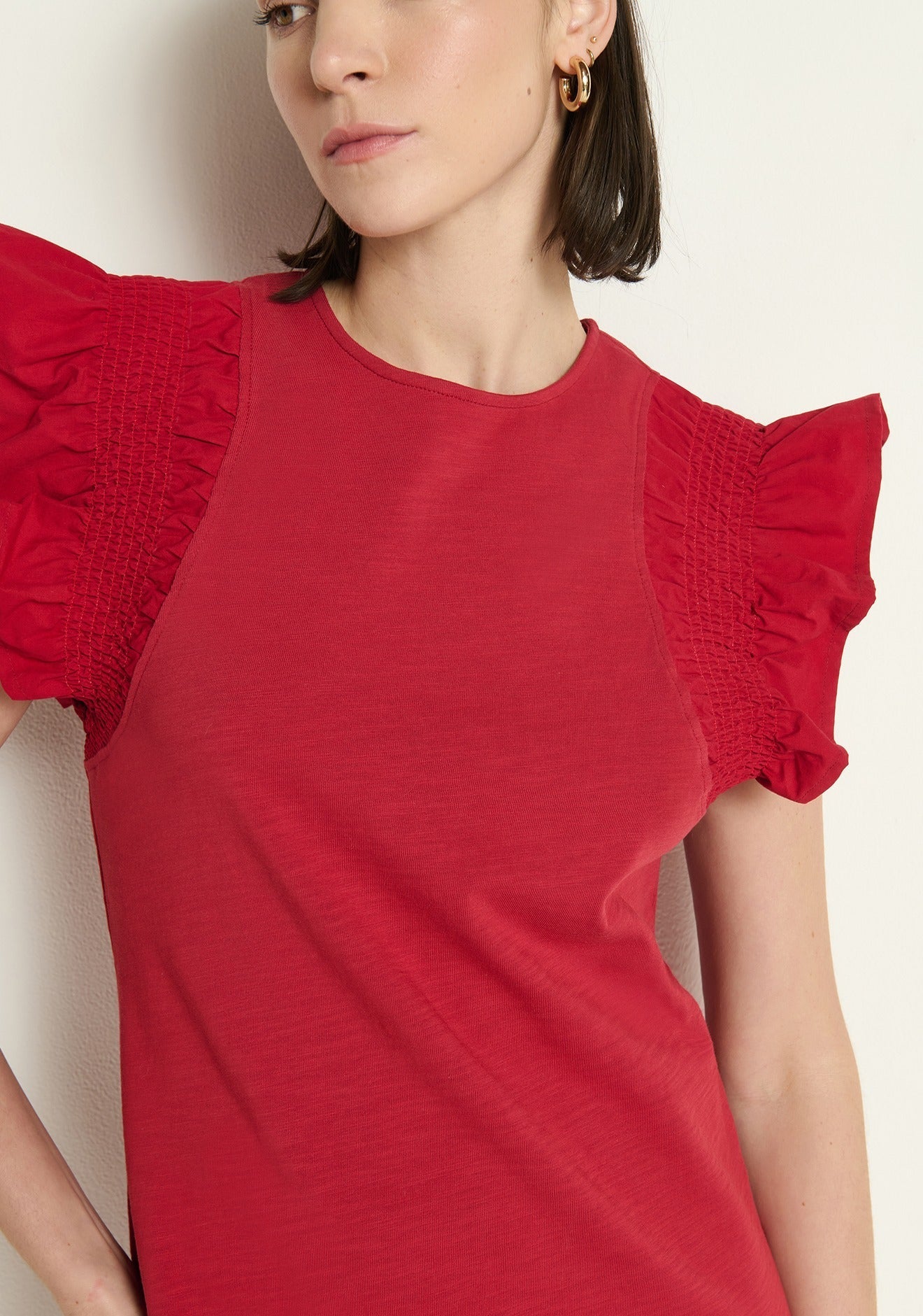 Close-up of the Nation Los Angeles Ellis Ruffle Sleeve Dress in Rio Red, highlighting the crew neckline and textured cotton fabric.