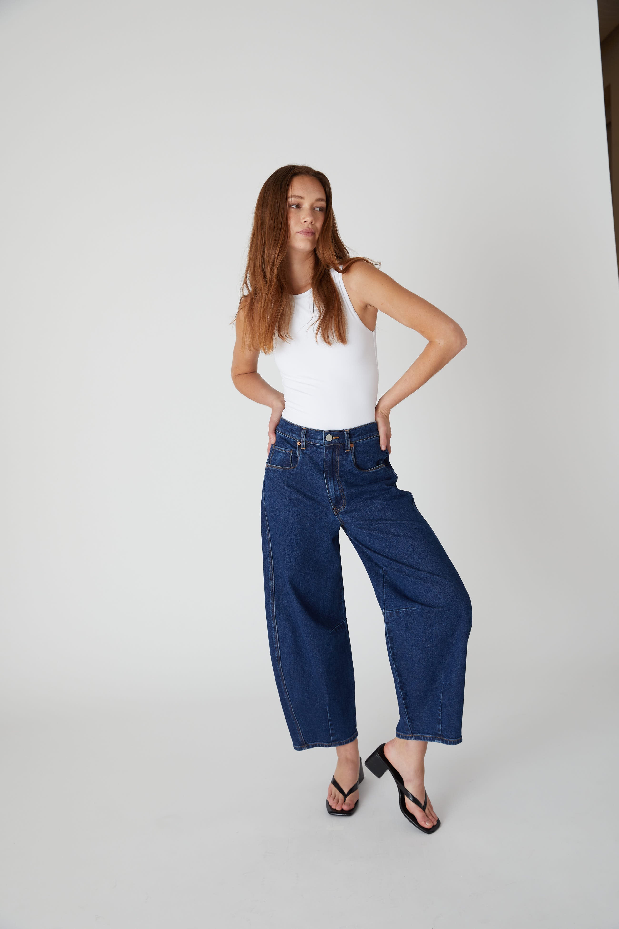Model wearing the BLANKNYC Deep Down Barrel Jean in Dark Indigo, front view.