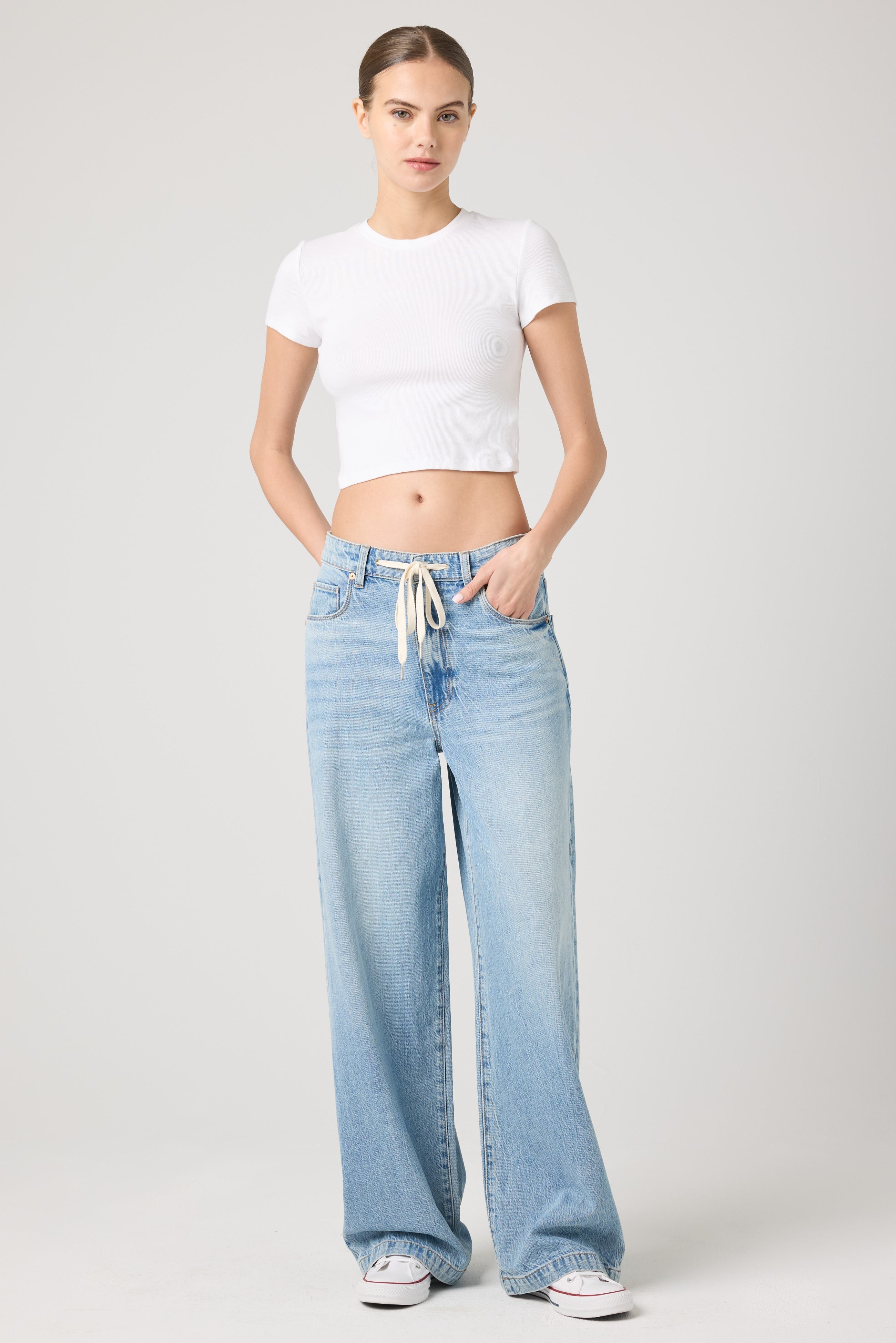 Model wearing the BLANKNYC Feeling Good Low-Rise Baggy Fit Denim Jean in Light Indigo, front view.
