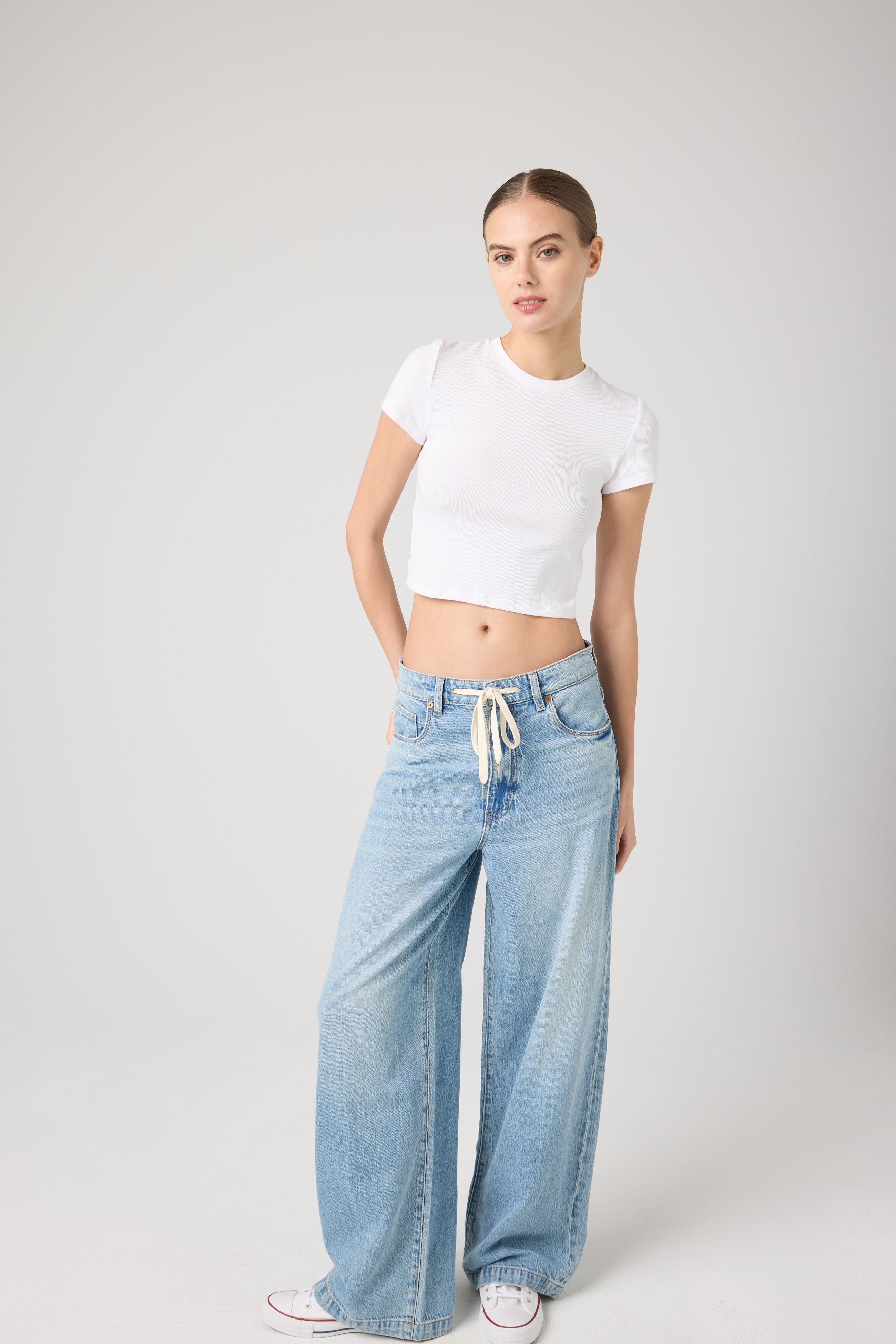 Model wearing the BLANKNYC Feeling Good Low-Rise Baggy Fit Denim Jean in Light Indigo, front view.