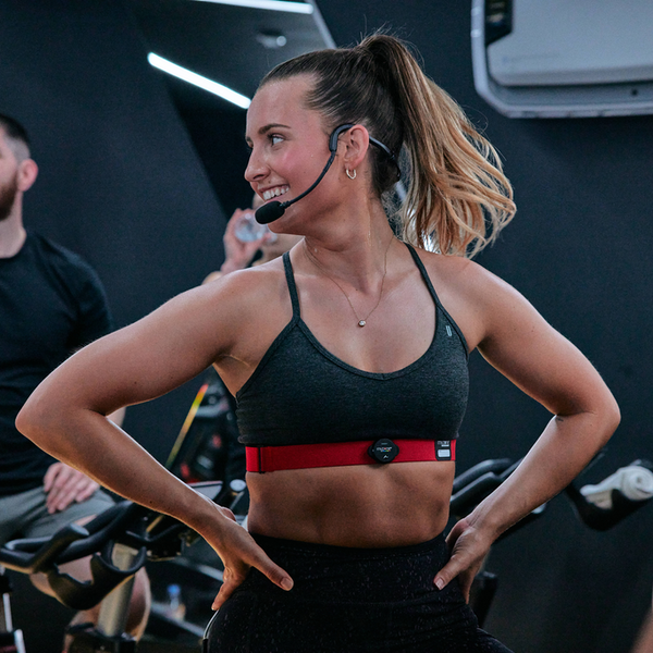 Close-up of the MYZONE MZ-Switch heart rate monitor on chest strap of group exercise instructor.