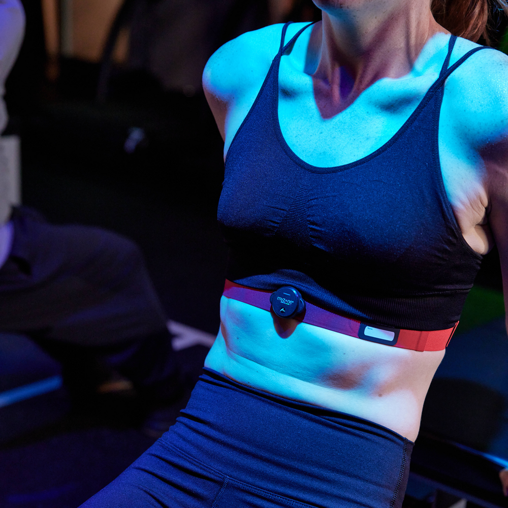 Close-up of the MYZONE MZ-Switch heart rate monitor on chest strap of woman.