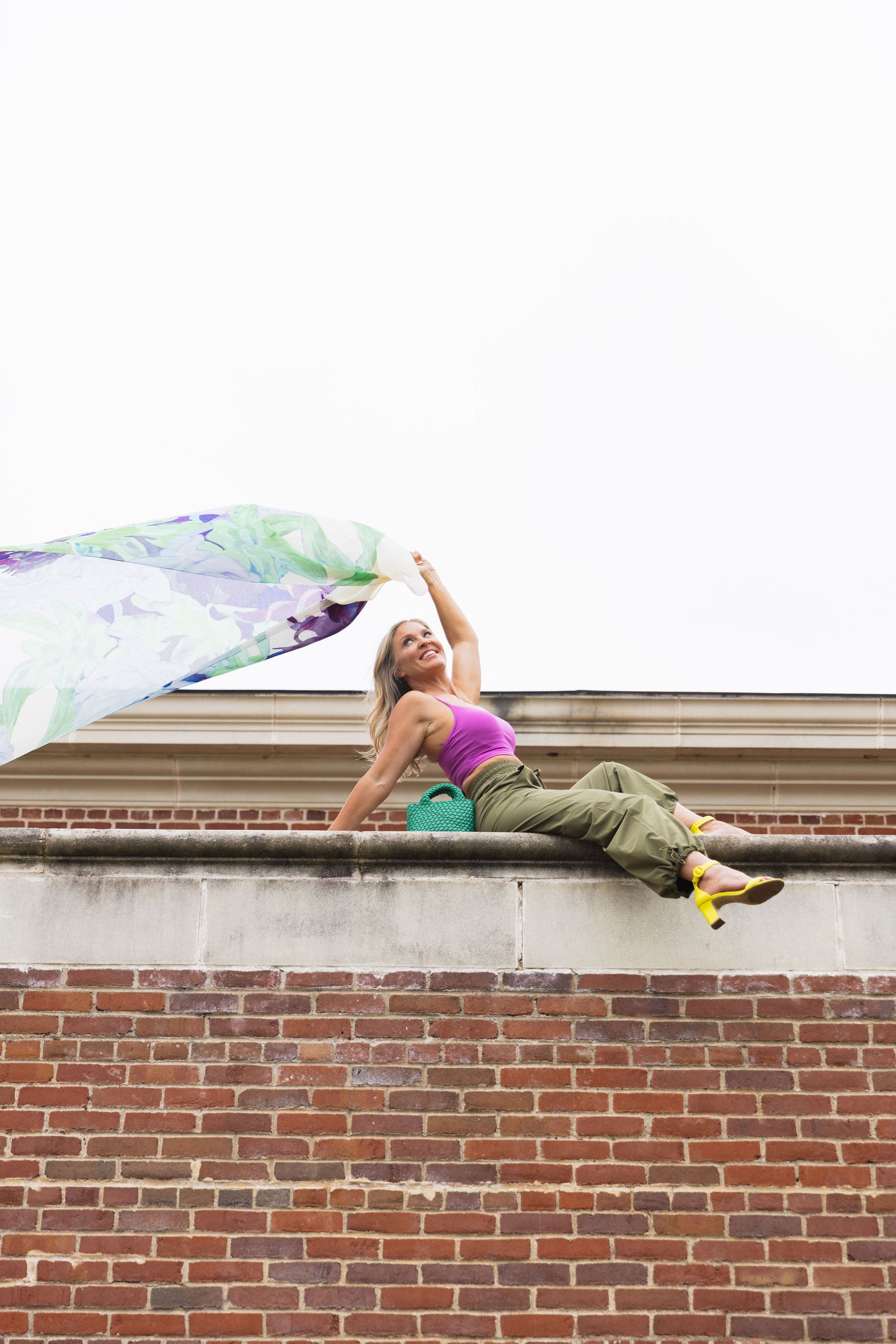 Model wearing the Be Fit Convertible Cargo Pant in green, on top of a brick wall.