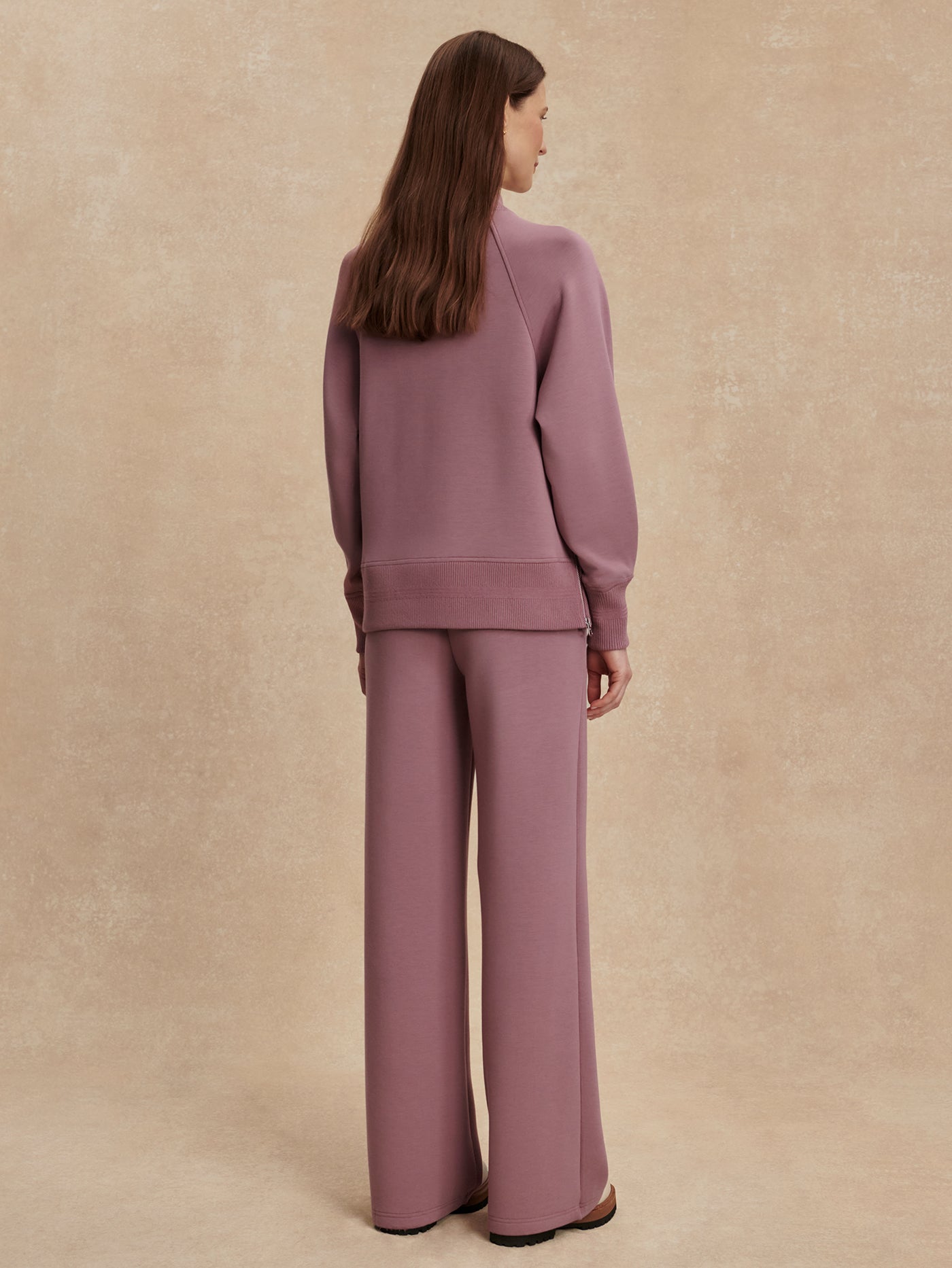 Back view of a model wearing the Varley The Wide Leg Pant 30" in Wistful Mauve.