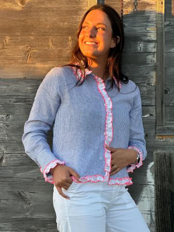 Model wearing the Vilagallo Pia Shirt in baby blue, front view, with white ruffle trim accented in pink.
