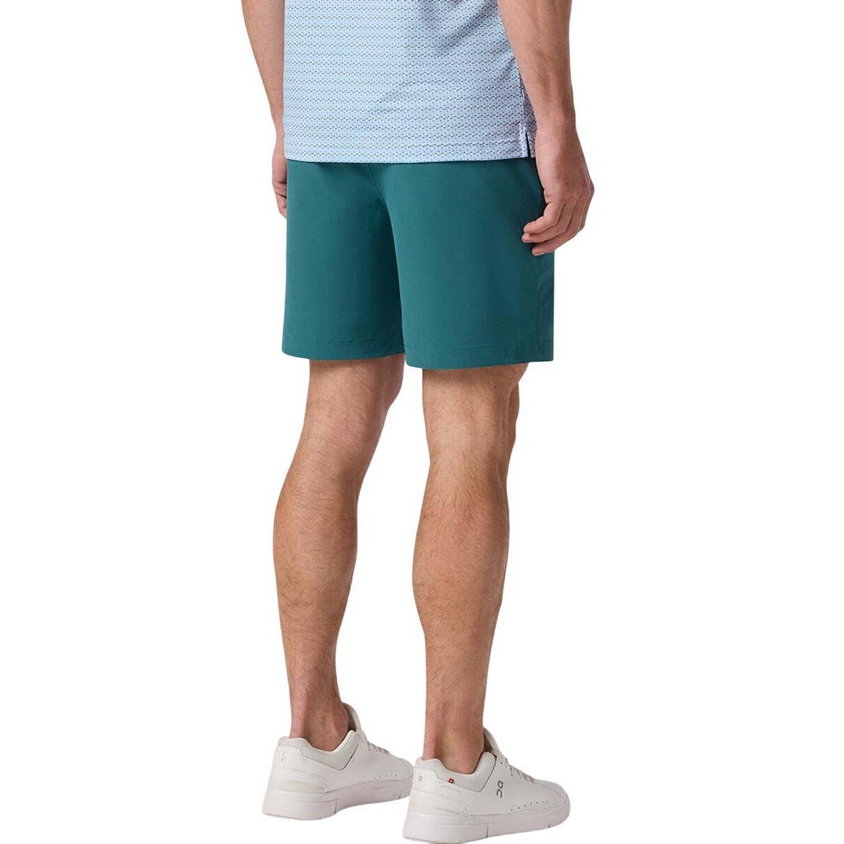 Rear view of a model wearing Mizzen+Main Helmsman Short in Balsam (deep green), showing the fit and length.
