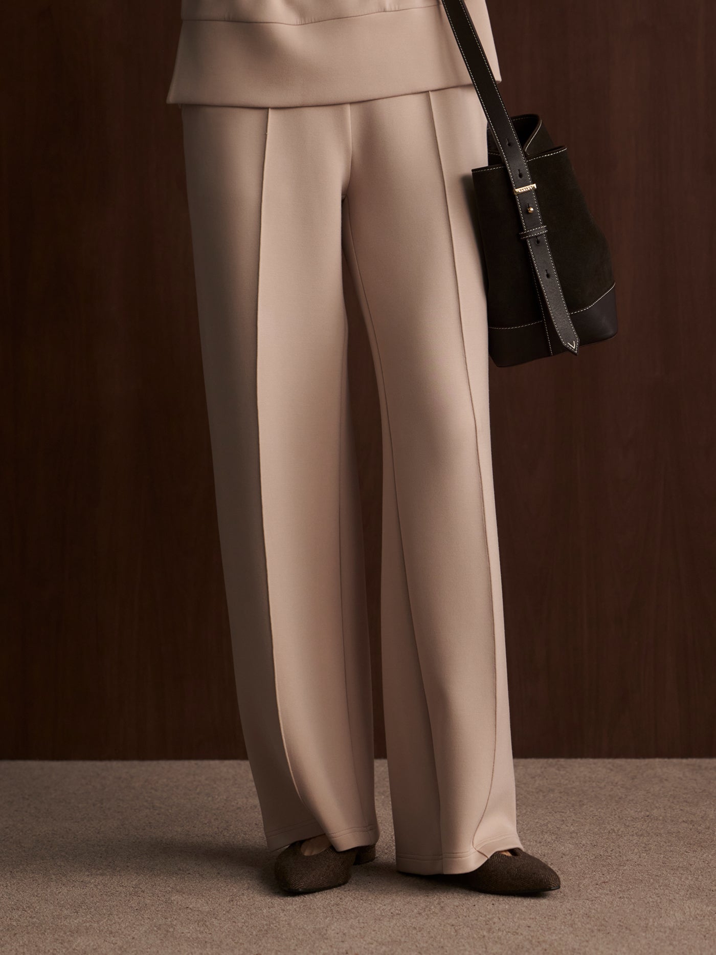 Close-up view of model wearing the Varley The Wide Leg Pant 28" in Mushroom, front view.