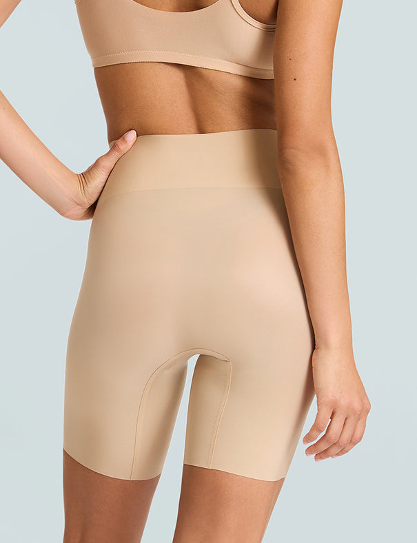 Close-up back view of the Nude Commando Zone Smoothing Short on a model, showing the seamless fit and raw-cut edges.