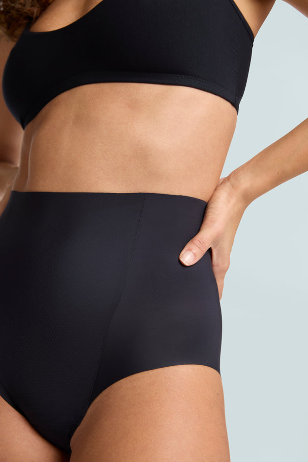 Close-up angled front profile view of the Commando Zone Smoothing Brief in black, highlighting the high-rise waistband and smooth fit.