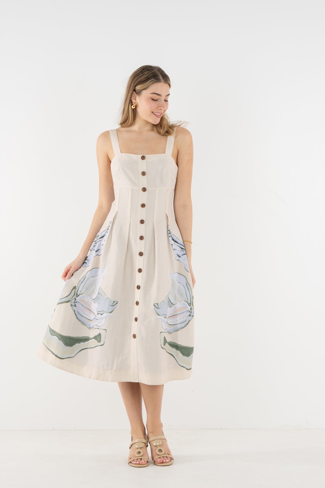 Model wearing Emily McCarthy Constance Midi Dress in the Lavender Fields print on a cream background with a green and blue botanical design.