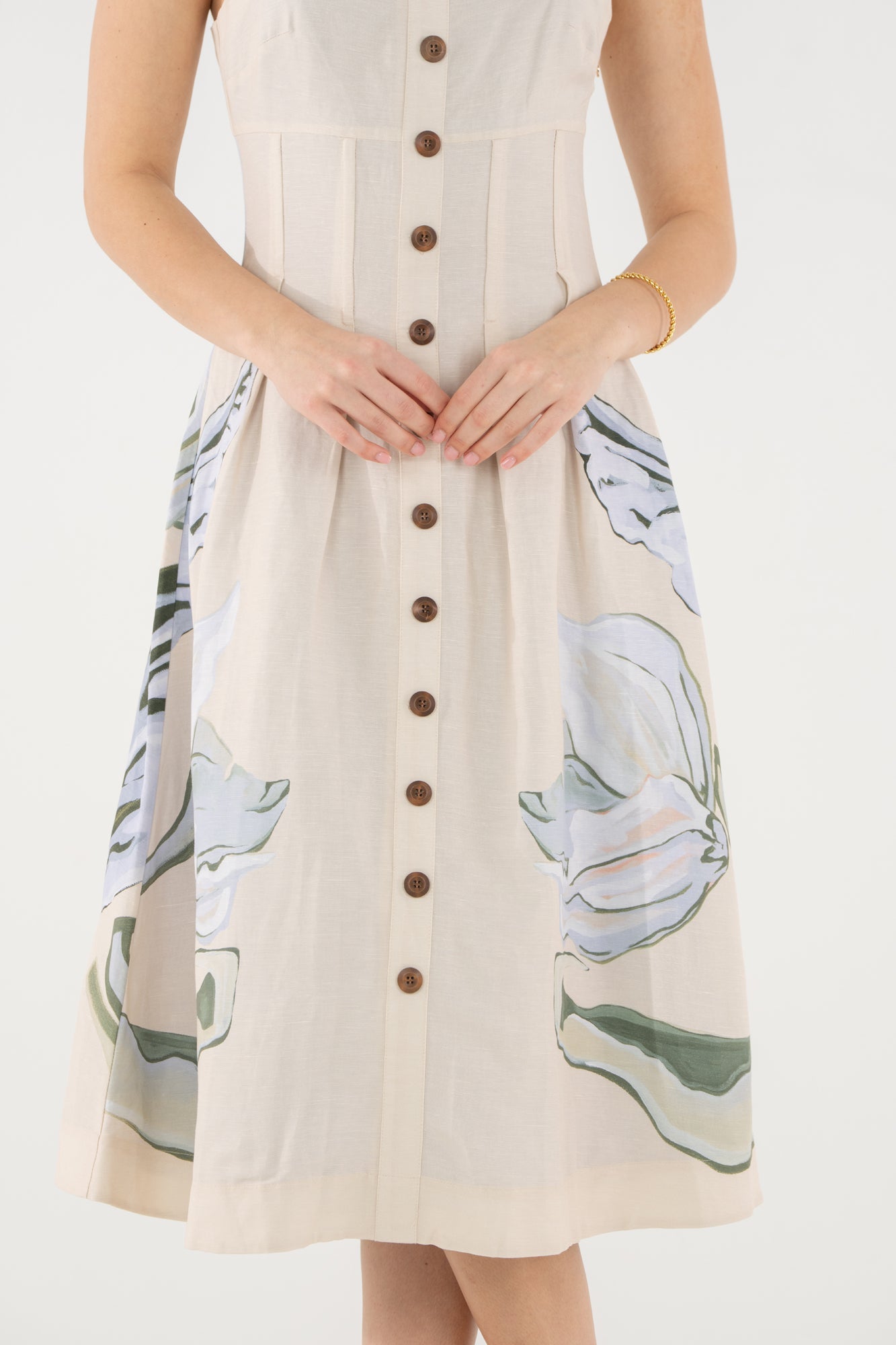 Model wearing the Emily McCarthy Constance Midi Dress in the Lavender Fields print on a cream background with a green and blue botanical design, front view.