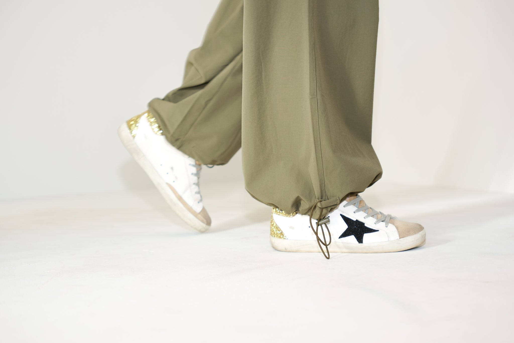 Close-up of the Be Fit Convertible Cargo Pant in green, highlighting the adjustable bungee openings at the hems.
