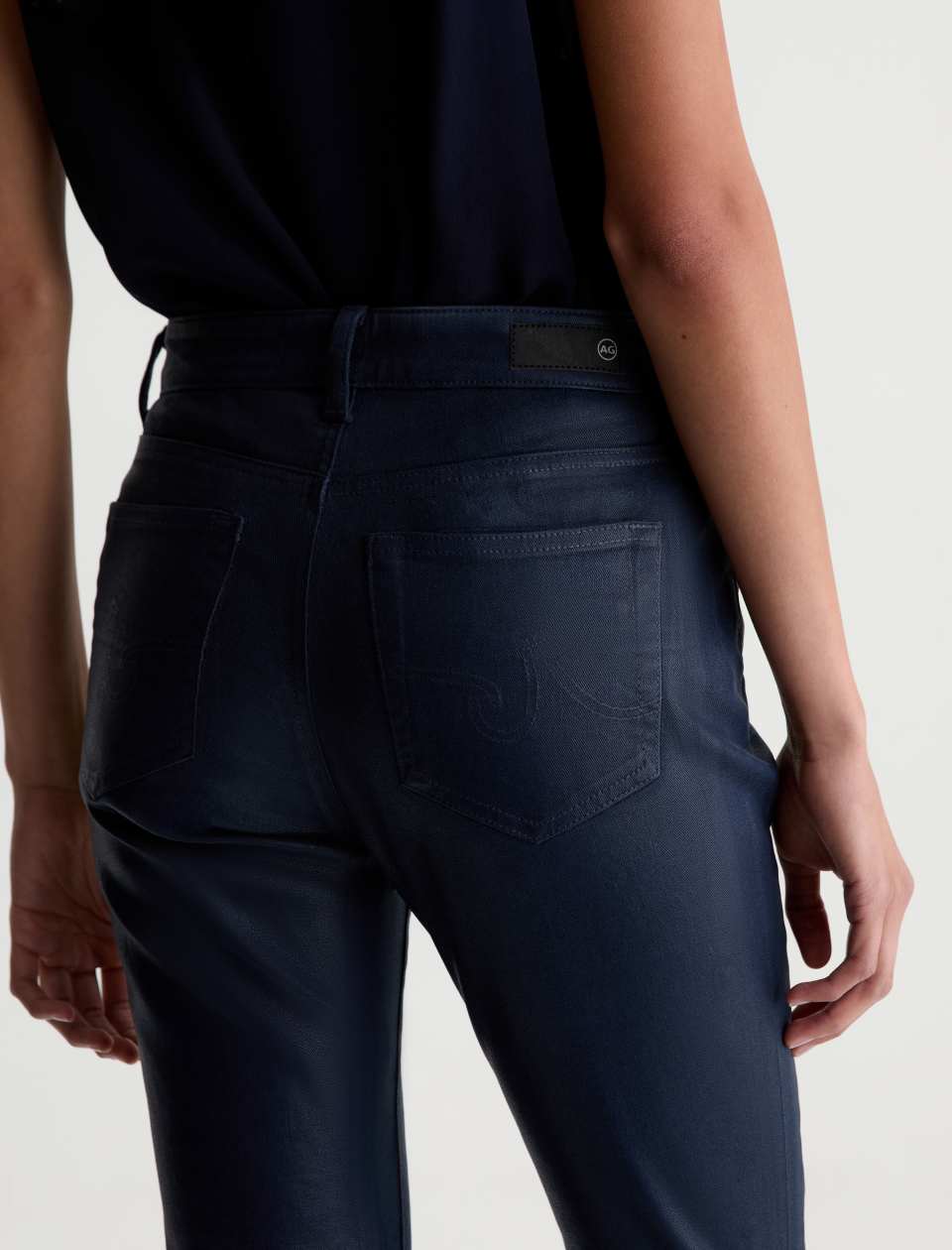 Close-up of the AG Mari Coated Jean’s back pockets, waistband and AG label.
