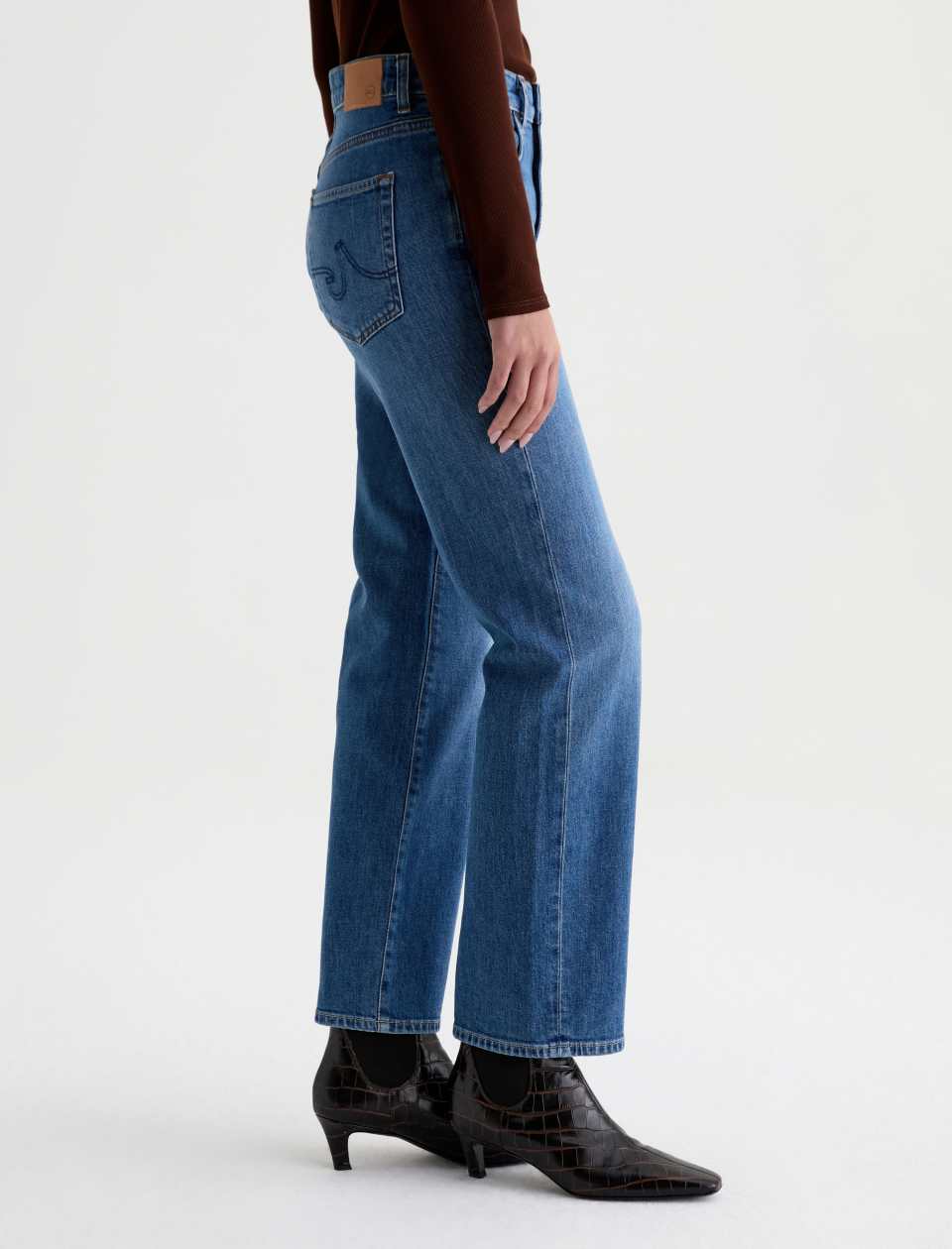 Side view of the AG Jeans Brinley Mid-Rise Jean in Chord on a model, showing the fit from hip to hem.