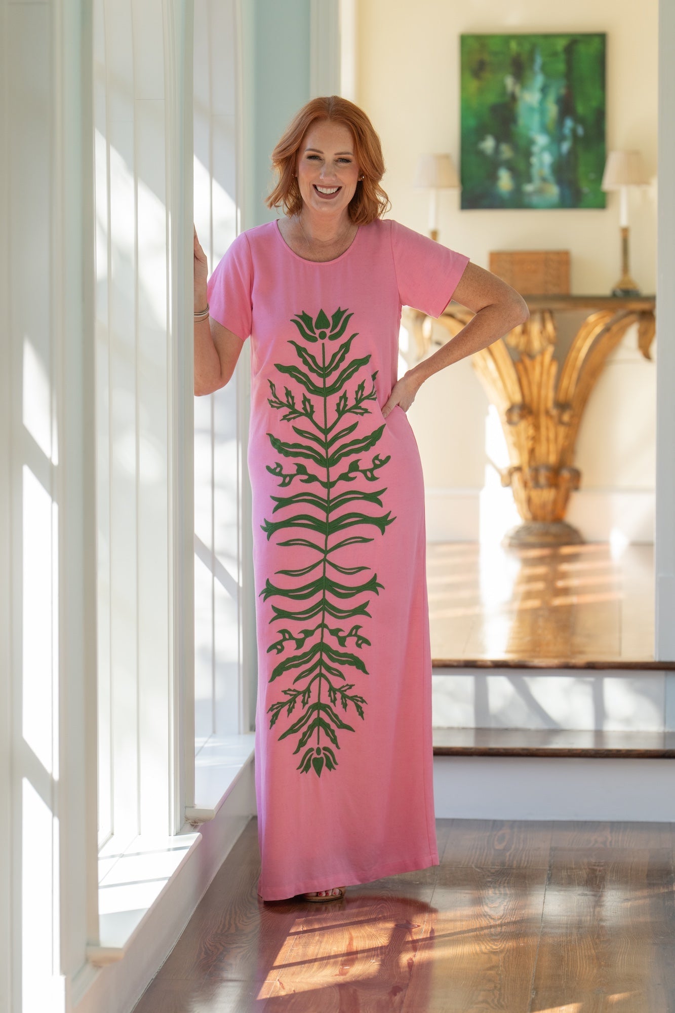 Model wearing the Emily McCarthy Cornelia Dress in Rosé, front view, featuring dark green floral appliqué.