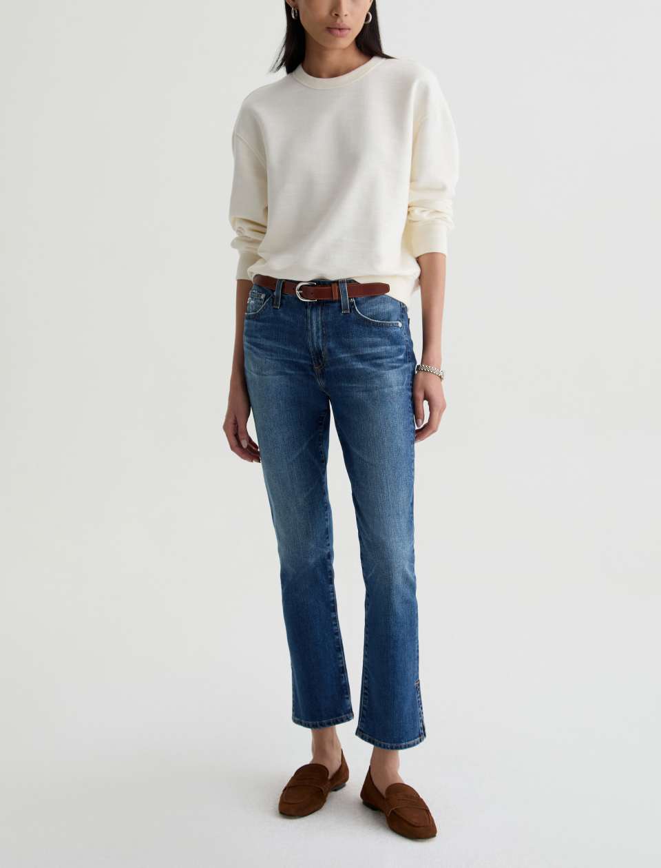 Front view of model wearing Mari Crop Jean in 15 Years Prague by AG Jeans with ivory sweater. 