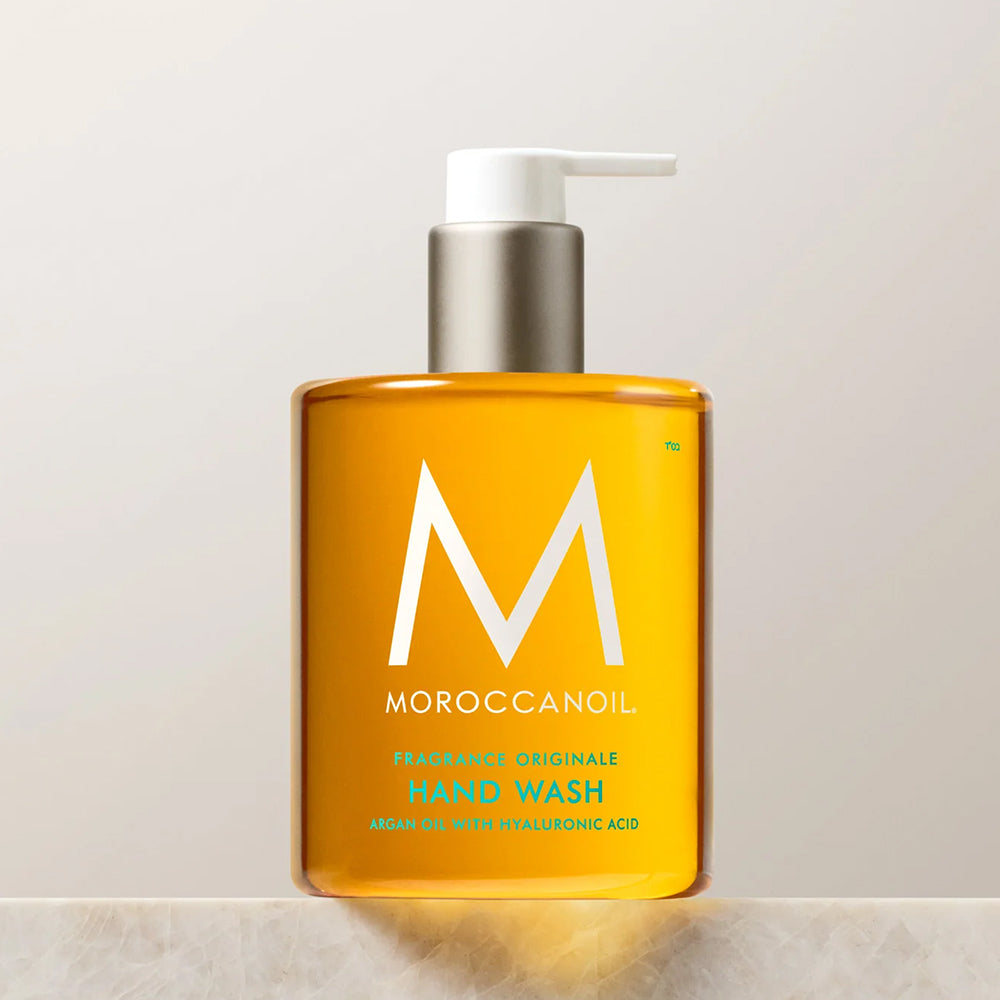 A golden-colored pump bottle of Moroccanoil Fragrance Originale Hand Wash with argan oil and hyaluronic acid for gentle cleansing, 12.2 fl oz.