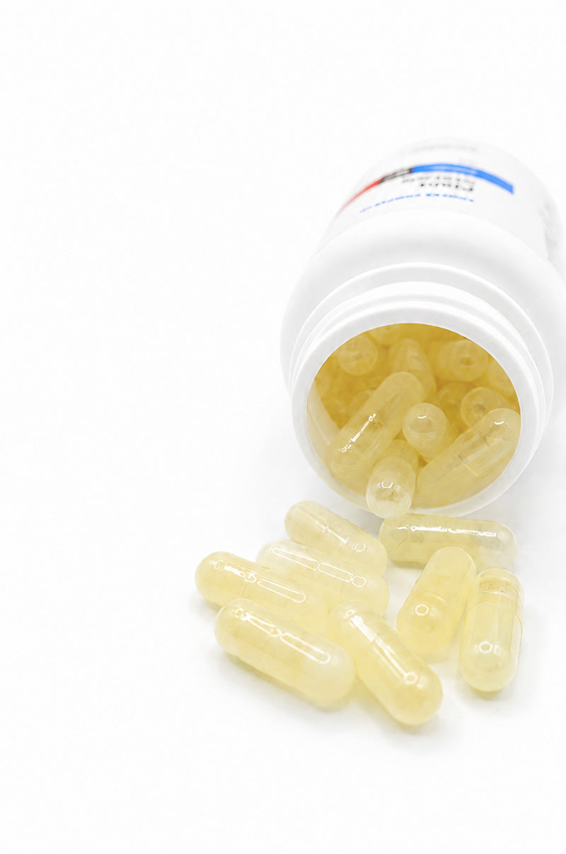 Cooper Complete Plant Sterol capsules spilling out of a white supplement bottle on a white background