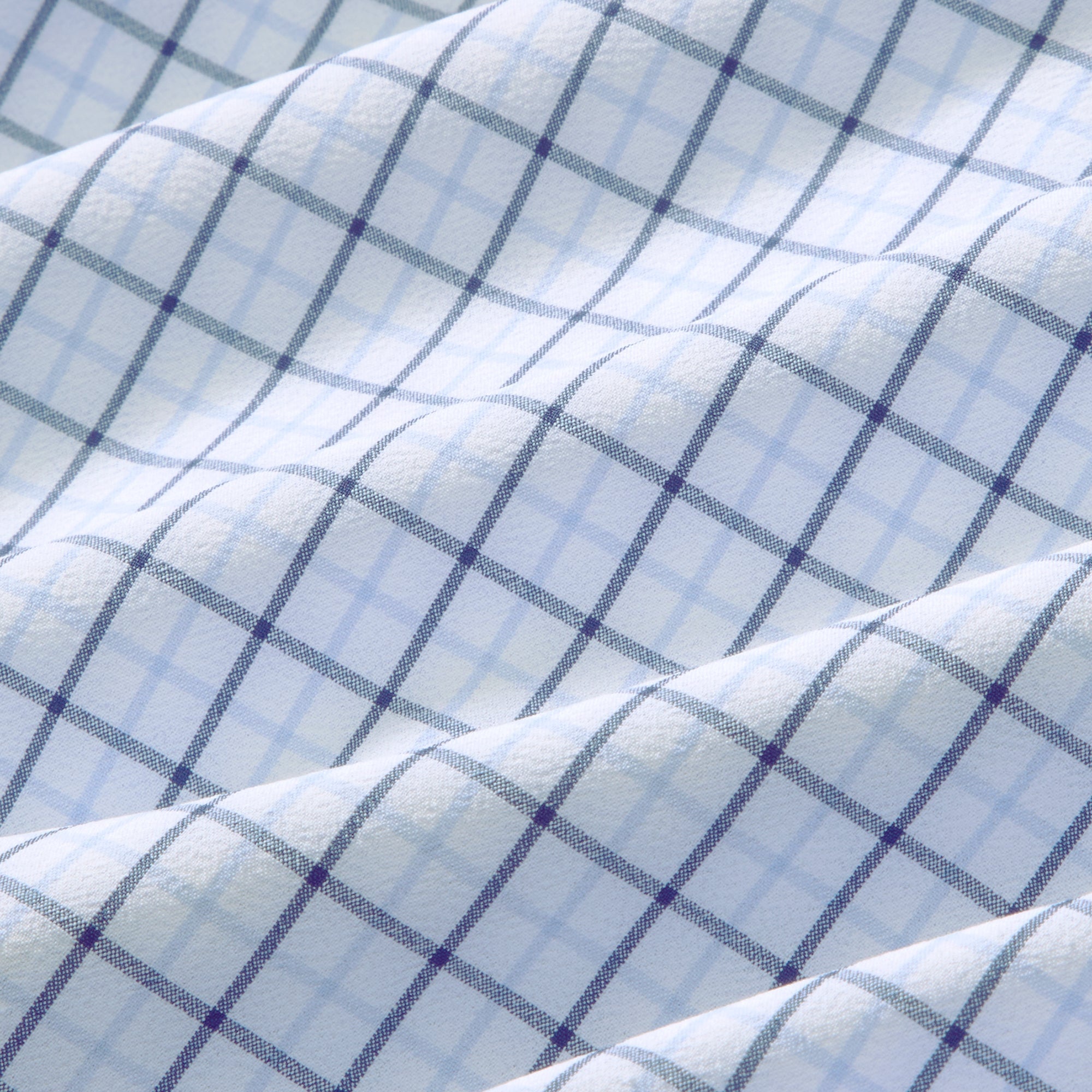 Fabric swatch of the Mizzen+Main Leeward Long Sleeve Dress Shirt in Cloud Blue Wyatt Plaid (light blue and white plaid), showing the lightweight four-way stretch performance fabric and plaid pattern.