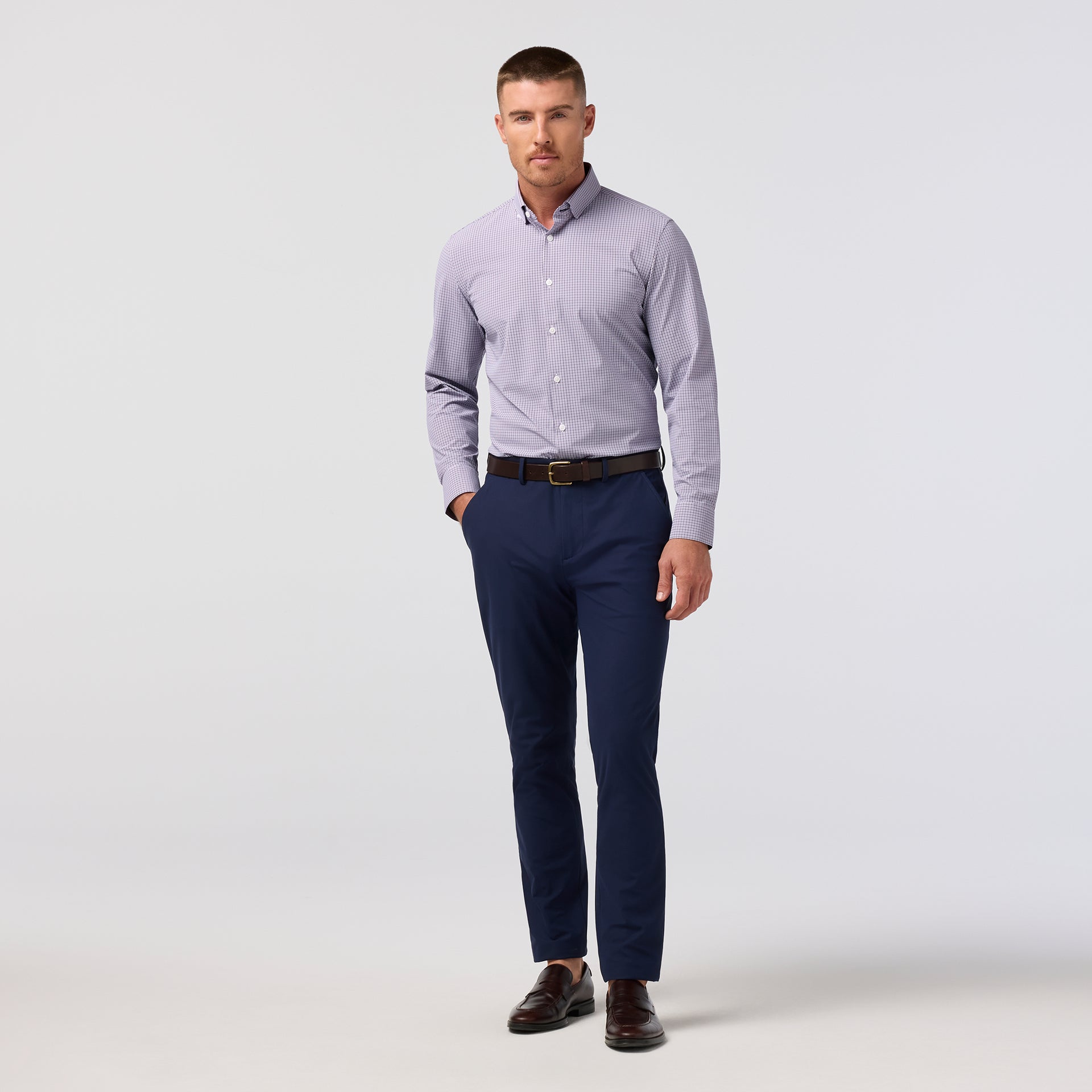 Model wearing the Mizzen+Main Leeward Long Sleeve Dress Shirt (Trim Fit) in Purple Dusk Sam Plaid (soft lavender and navy plaid), showing the tailored fit and spread collar.