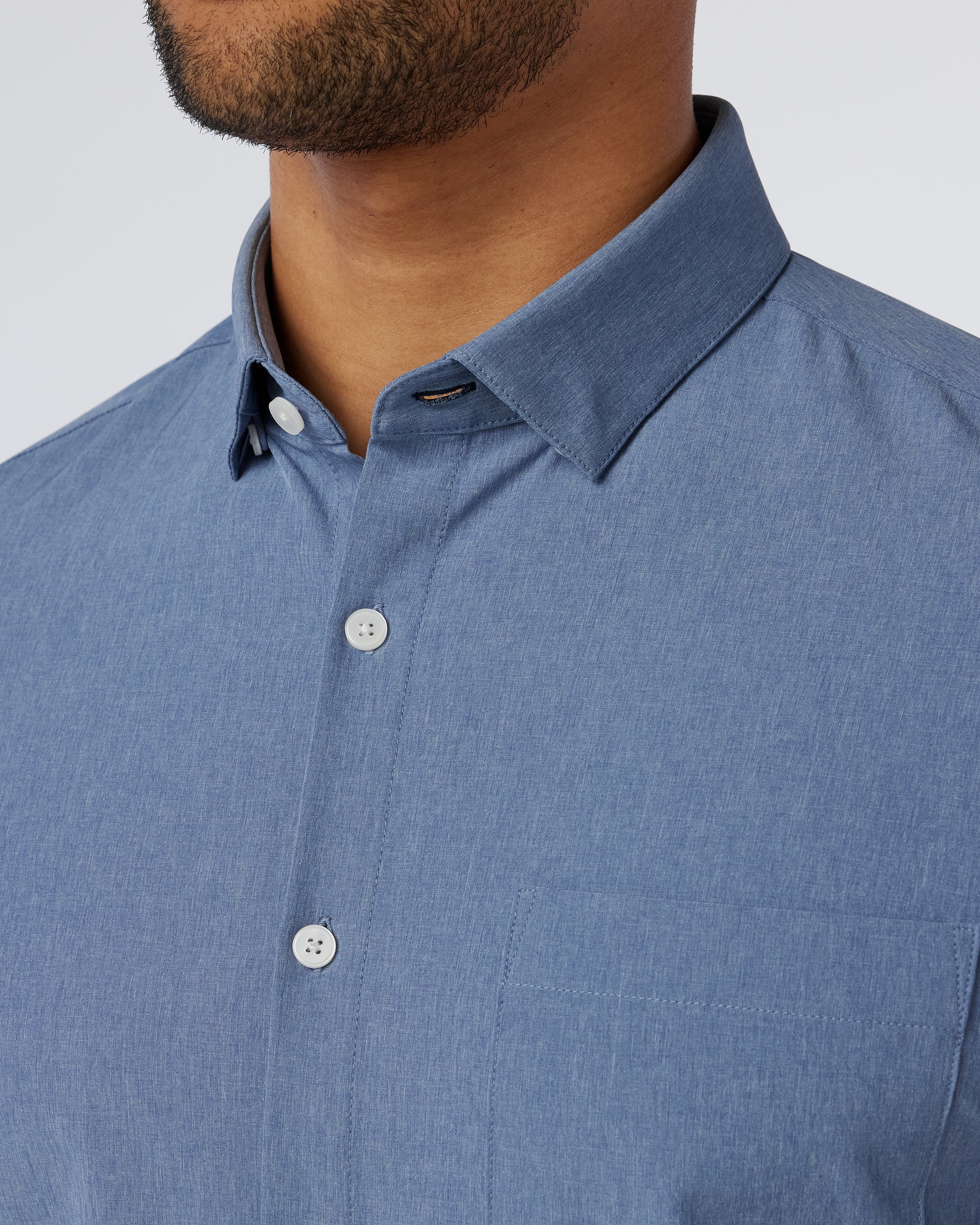Close-up of the spread collar and neckline on the Mizzen+Main Leeward Short Sleeve Dress Shirt in Coastal Fjord Heather (chambray blue).