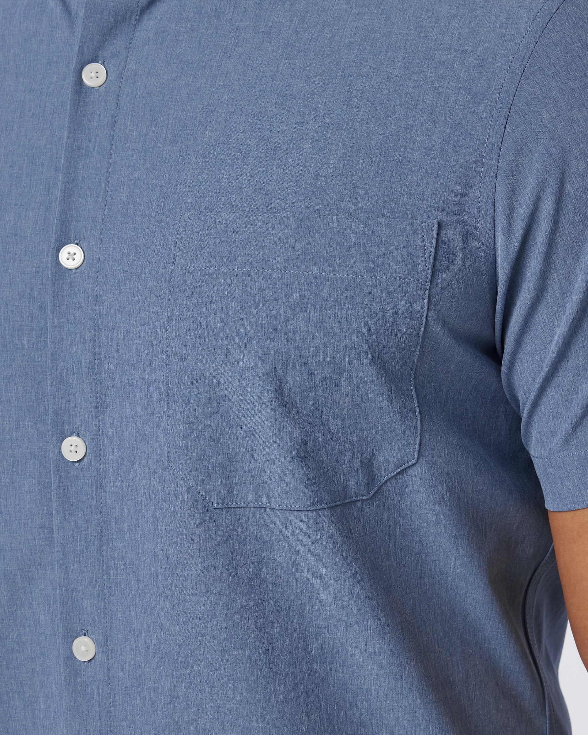Close-up of the buttons and left breast pocket on the Mizzen+Main Leeward Short Sleeve Dress Shirt in Coastal Fjord Heather (chambray blue).