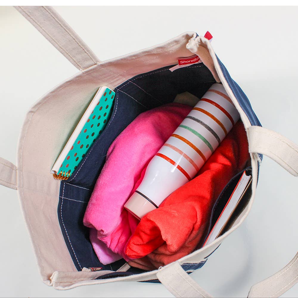 Open Cooper Fitness Center branded heavyweight natural canvas tote showing the spacious interior with multiple organizer pockets.